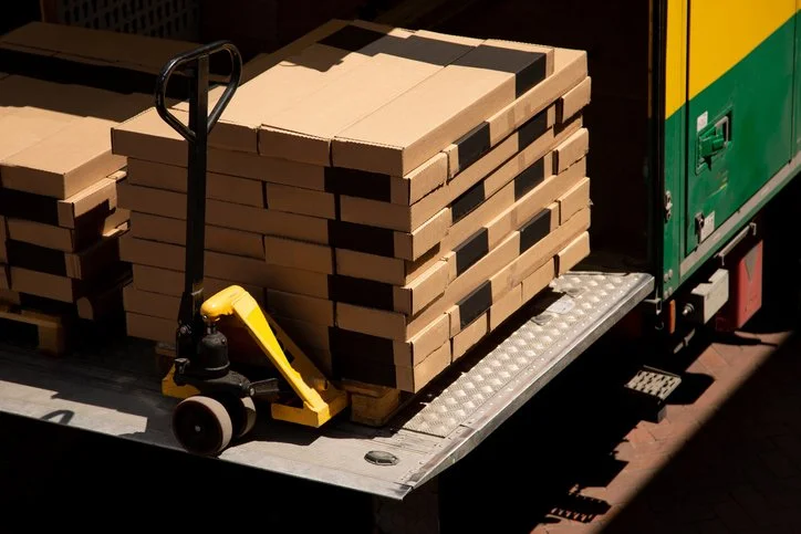 Stacked boxes on a pallet being loaded onto a tail lift for UK pallet delivery service.Stacked boxes on a pallet being loaded onto a tail lift for UK pallet delivery service.