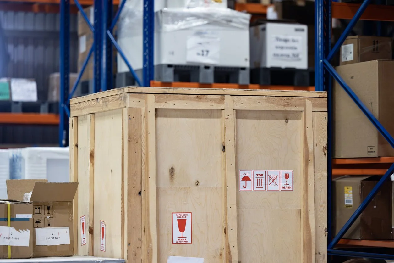 Crates with fragile stickers in on a pallet in a warehouse