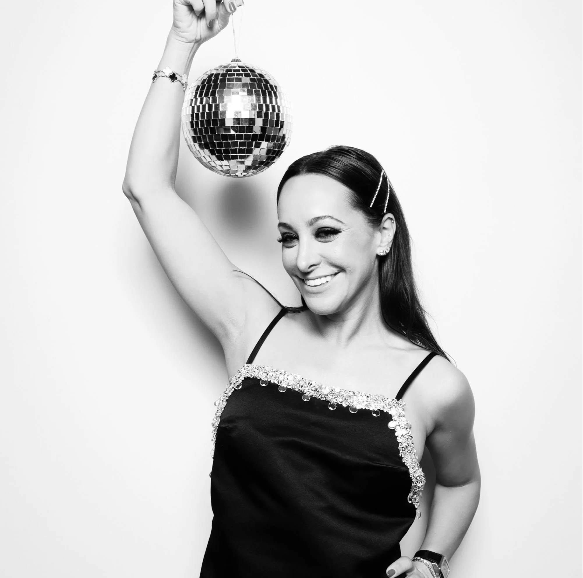 A woman holding a disco ball smiling