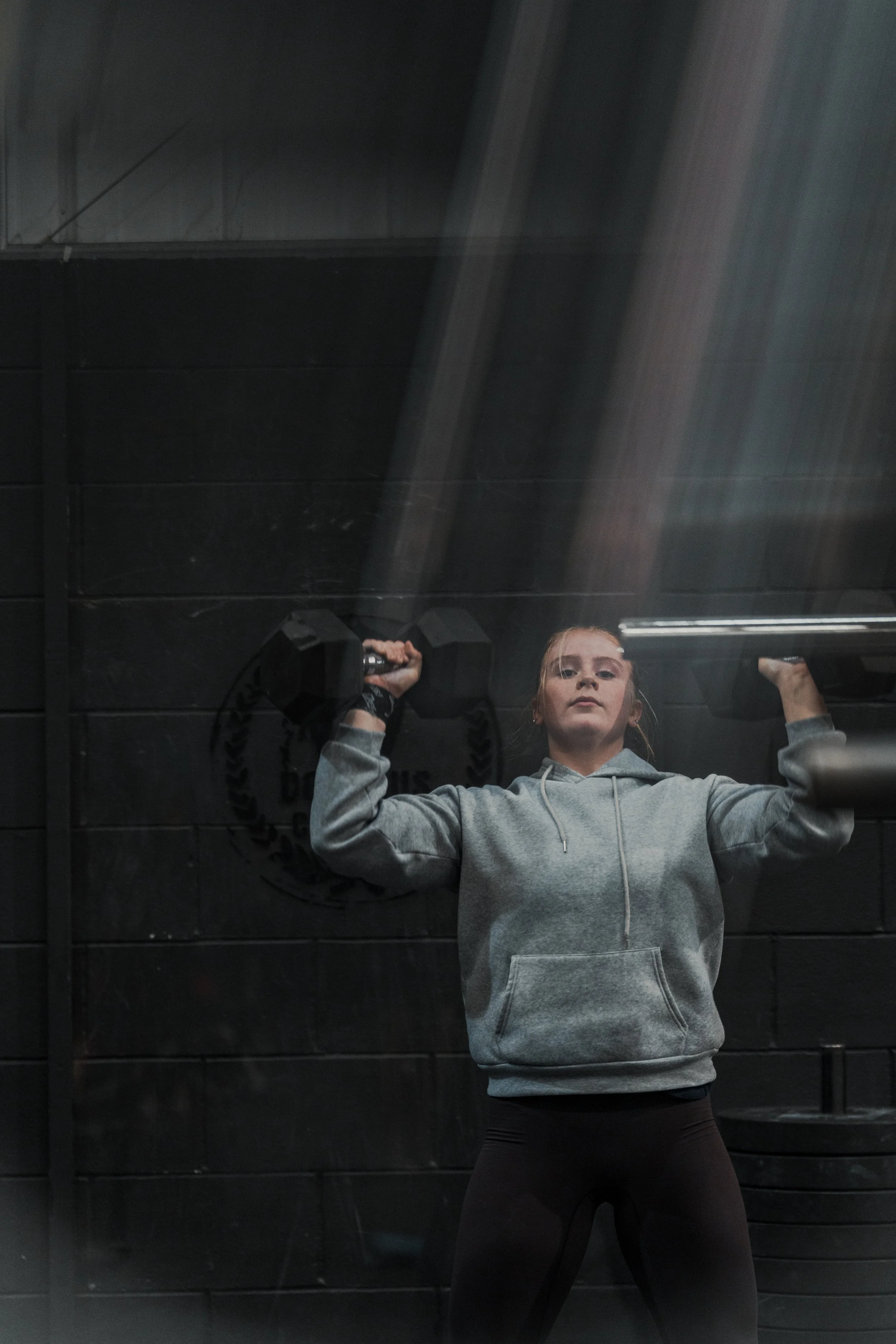 A young man lifting weights at a CrossFit Teens class