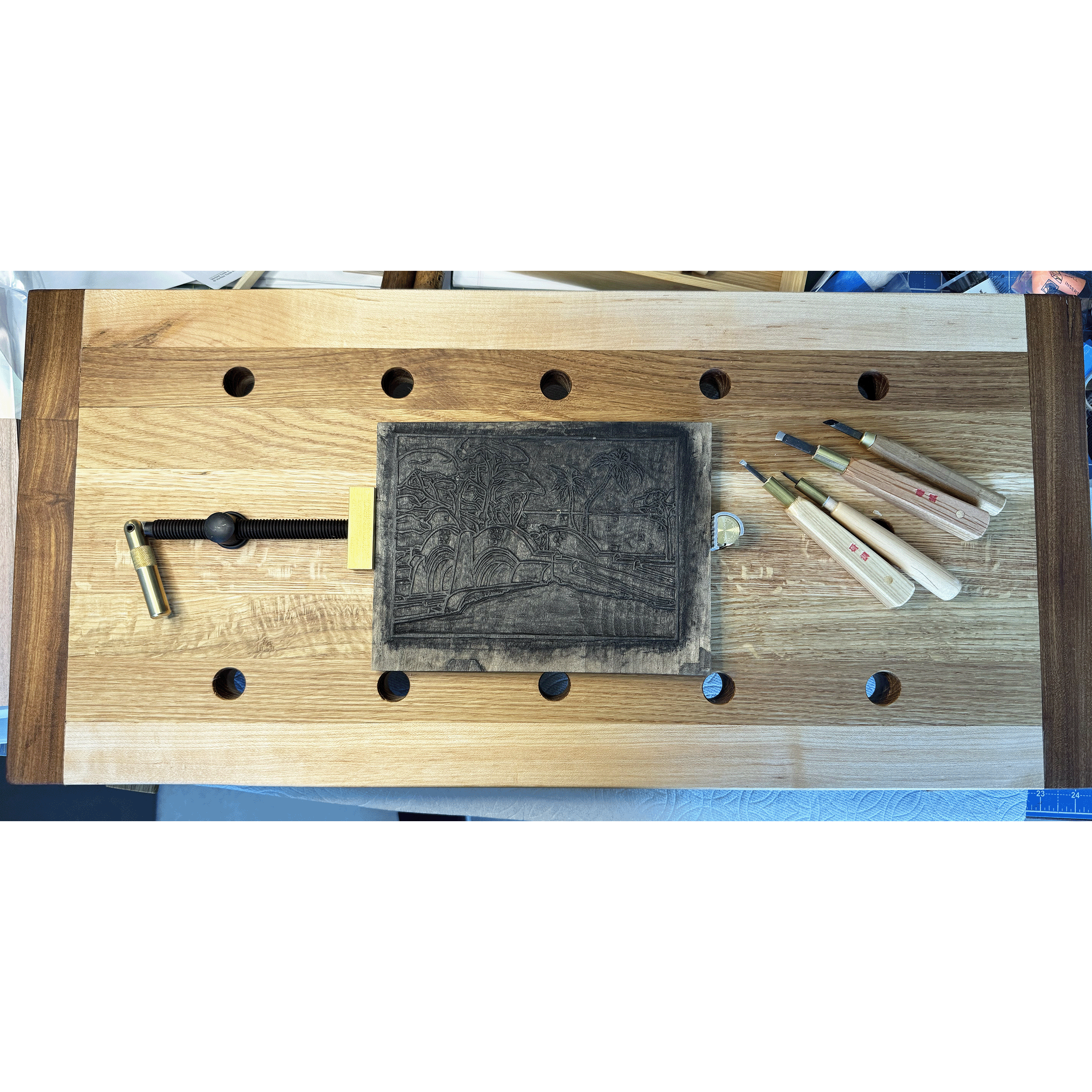 Table Top Woodblock Carving Bench, 2024. This 14" x 24" workbench is designed to lie flat or at a 15° angle on a regular desktop. The 15° angle up towards the back setting relieves stress on the wrist and forearm when carving. The angle reversed down