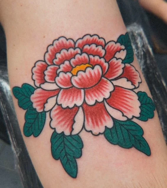 Red peony tattoo with green leaves by J. Betts at Black Letter Tattoo Company