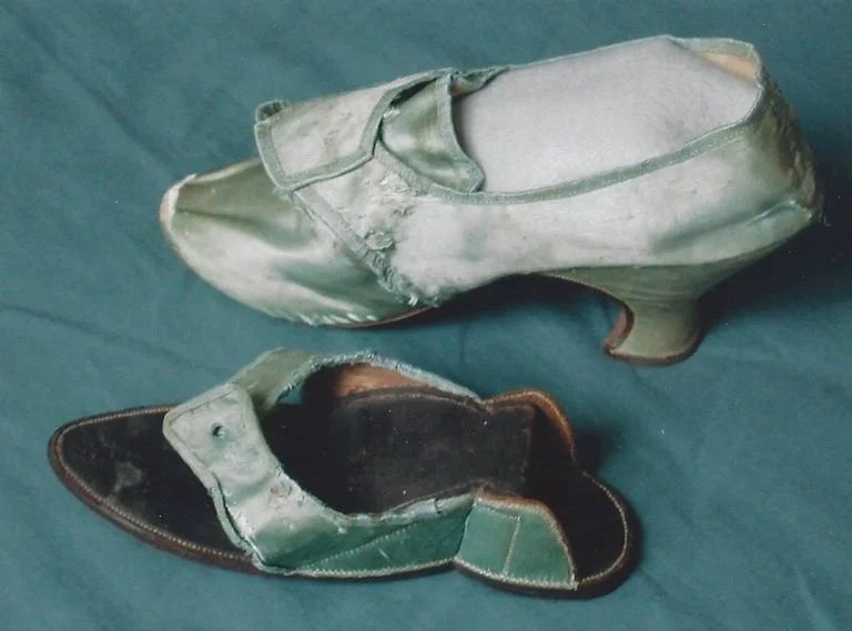 18th century single heeled shoe with light blue/green silk paired with a patten, which inserts around the heel to create a flat surface onto which one could walk.