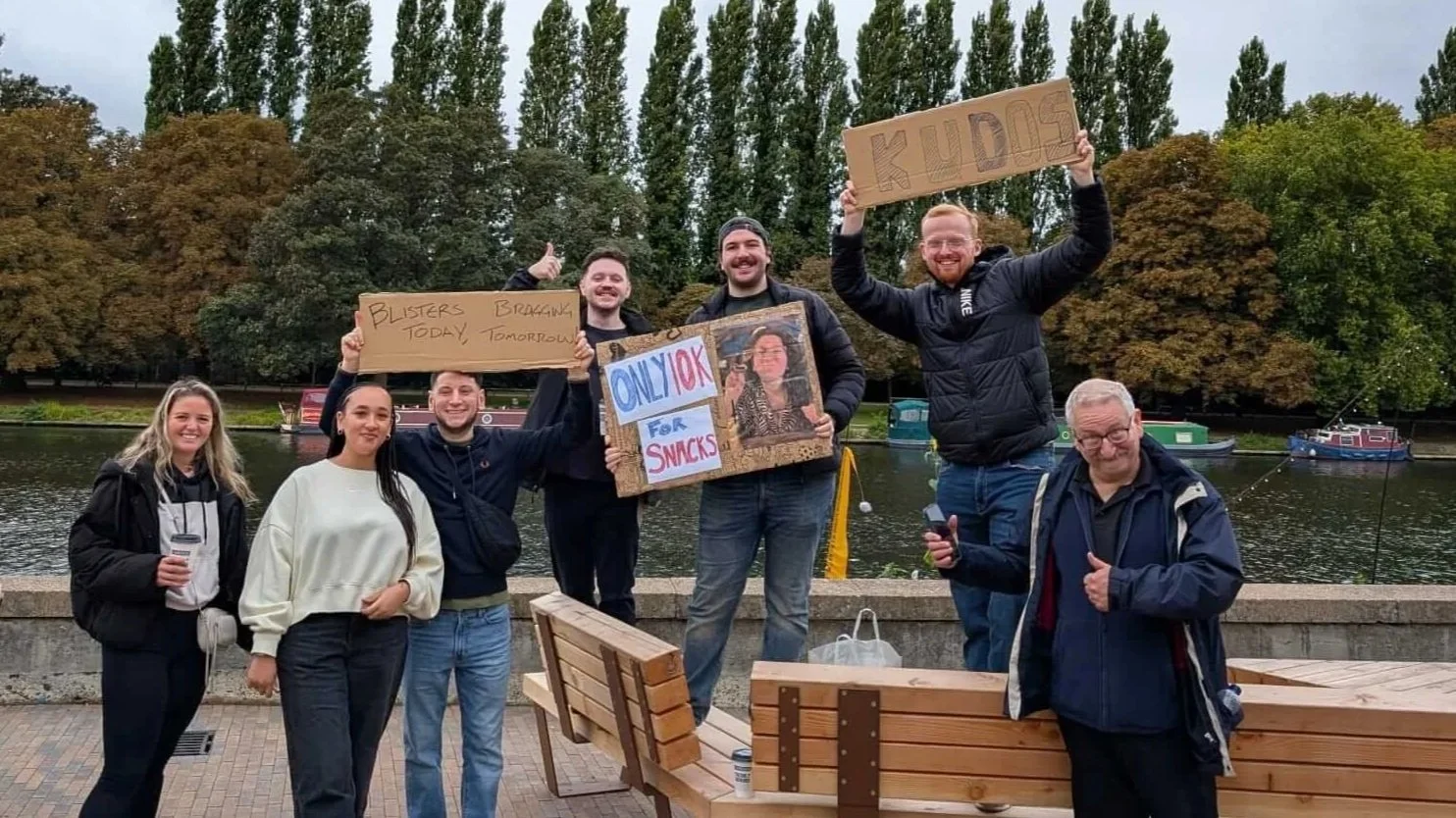 Freya's friends and family holding signs and cheering as Freya runs past at the marathon