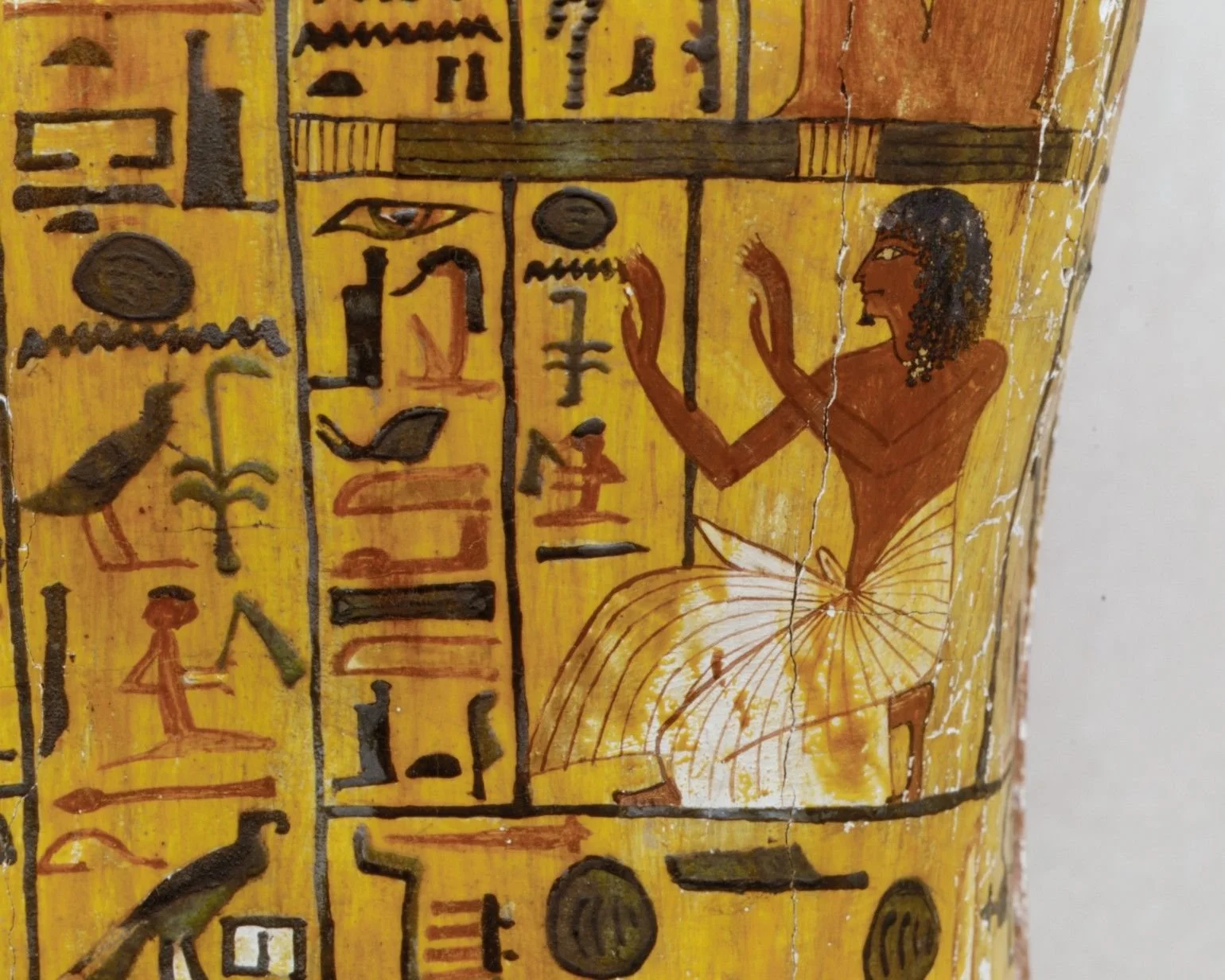 Khonsu kneeling with his hands raised in a gesture of adoration.