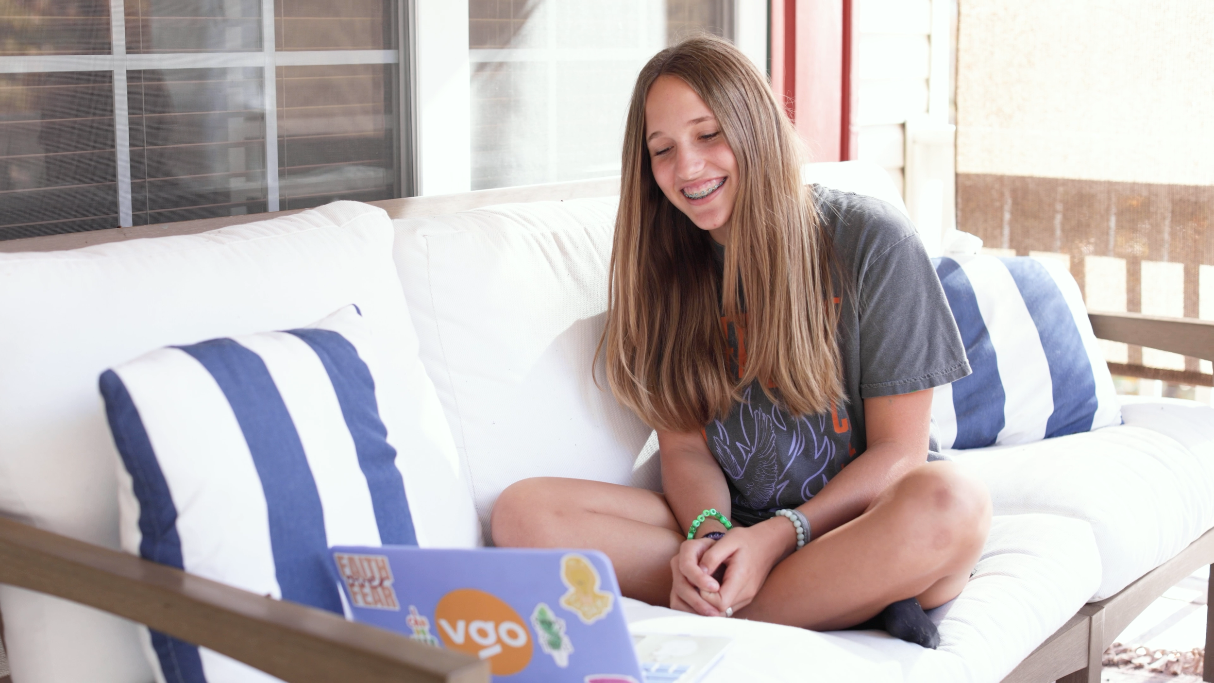 A Valor Global Online student smiling while learning from home on her laptop