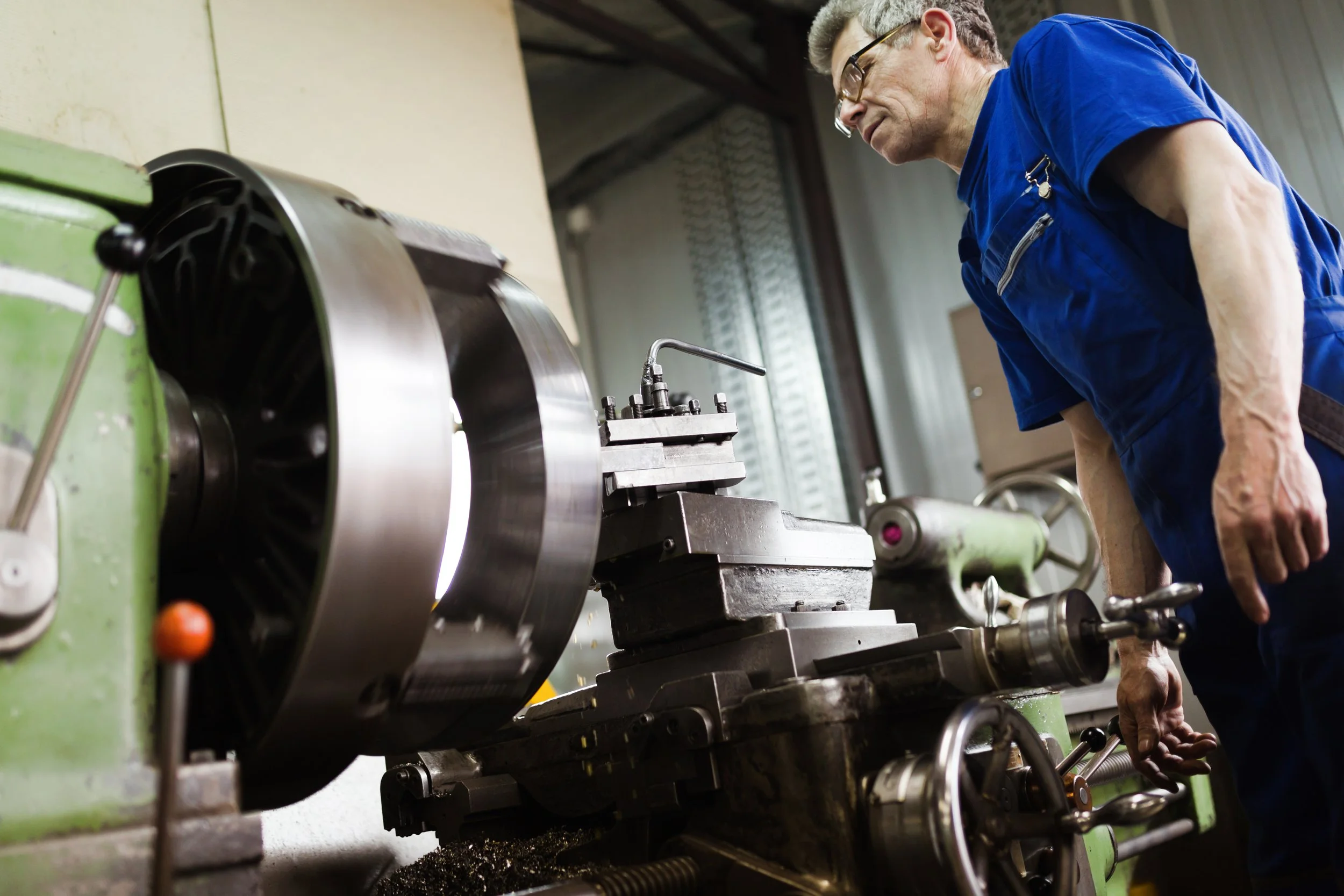 worker-in-uniform-operating-in-manual-lathe-in-met-2021-08-27-09-54-03-utc.jpg