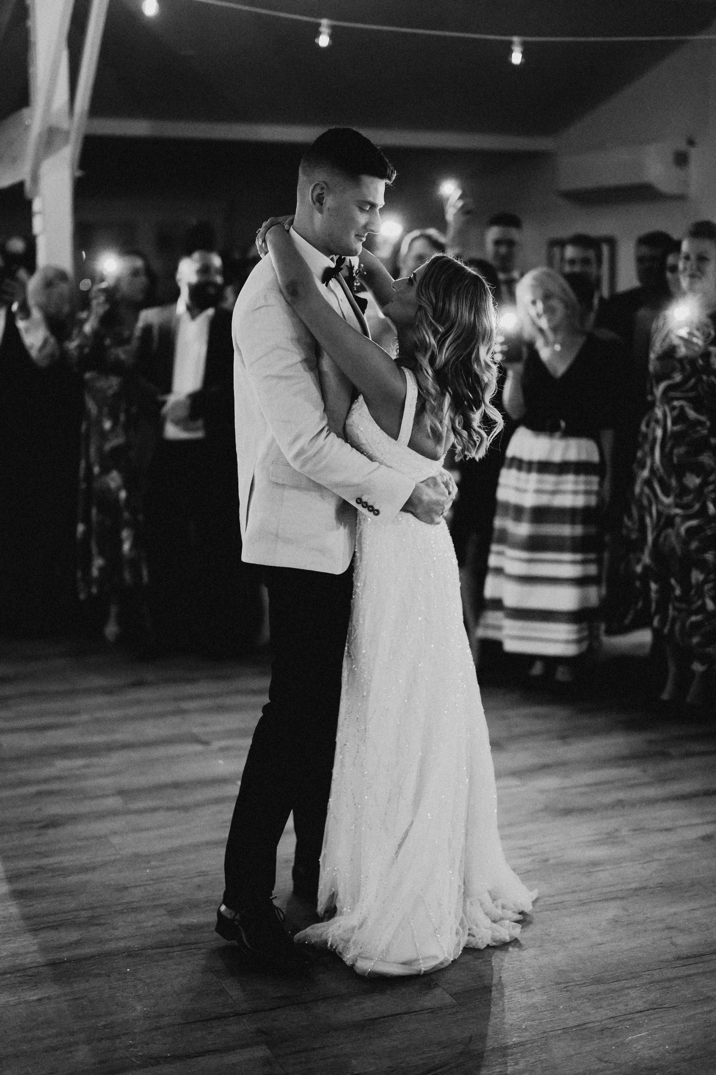 Nick holds Nicola close on the dancefloor at Bramleigh Estate, their guests gathered around them beneath the string lights.