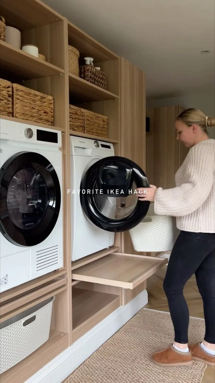 Mueble alto con lavadora y secadora elevados con bandejas de trabajo deslizables y espacio para colocar canastas
