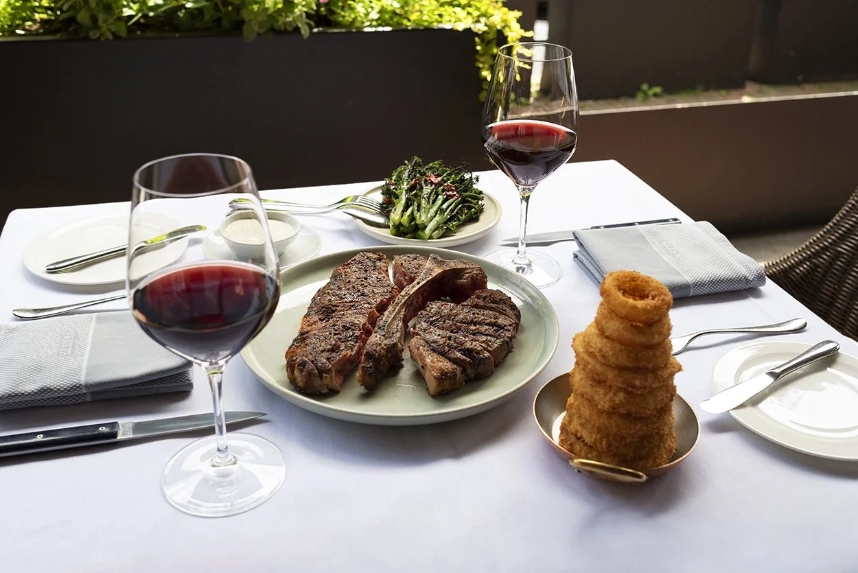04-steakhouse-tomahawk-steak-patio-red-wine-full-table.jpg