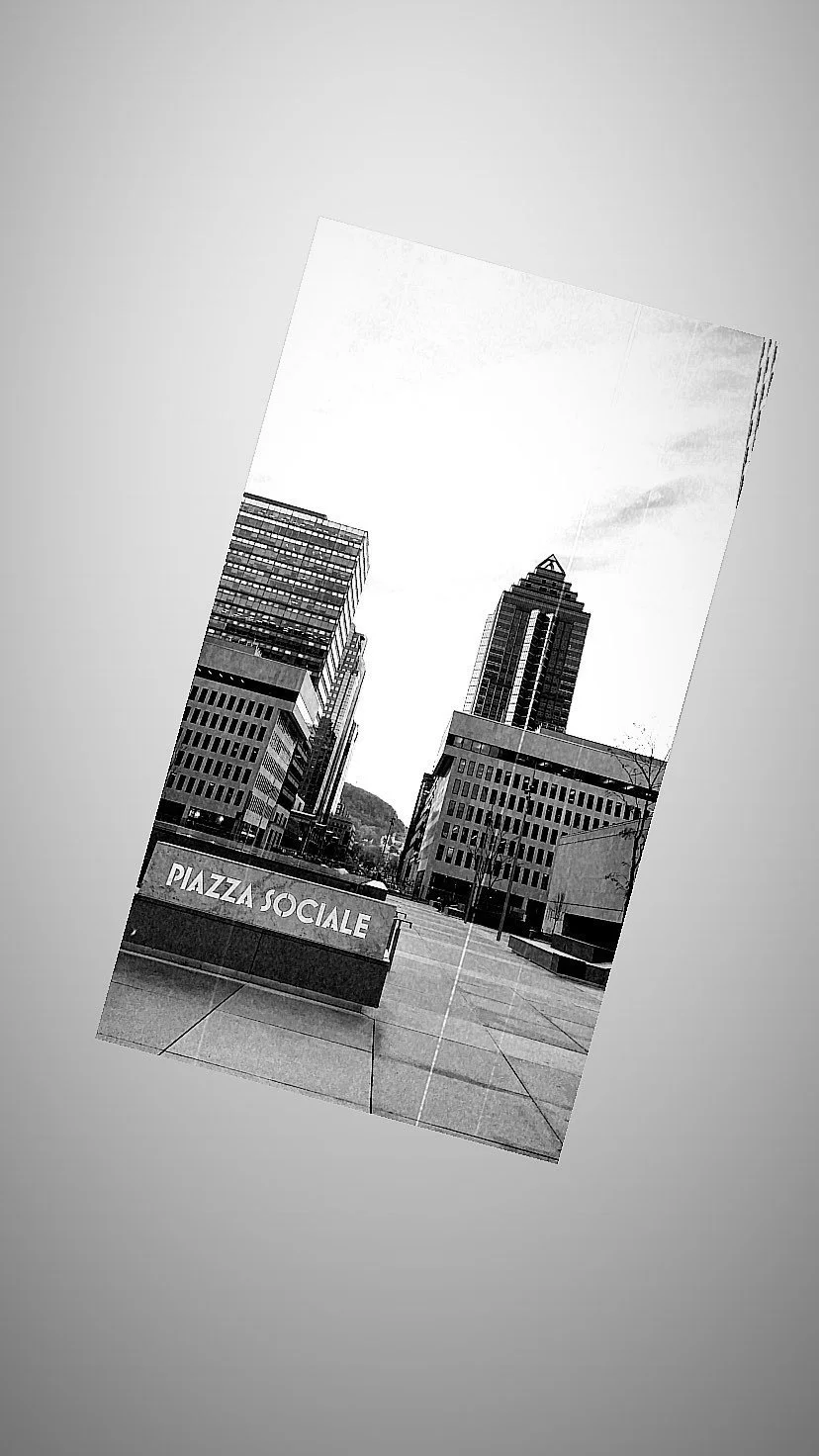 Black and white photo of urban buildings with a sign that reads "Piazza Sociale".