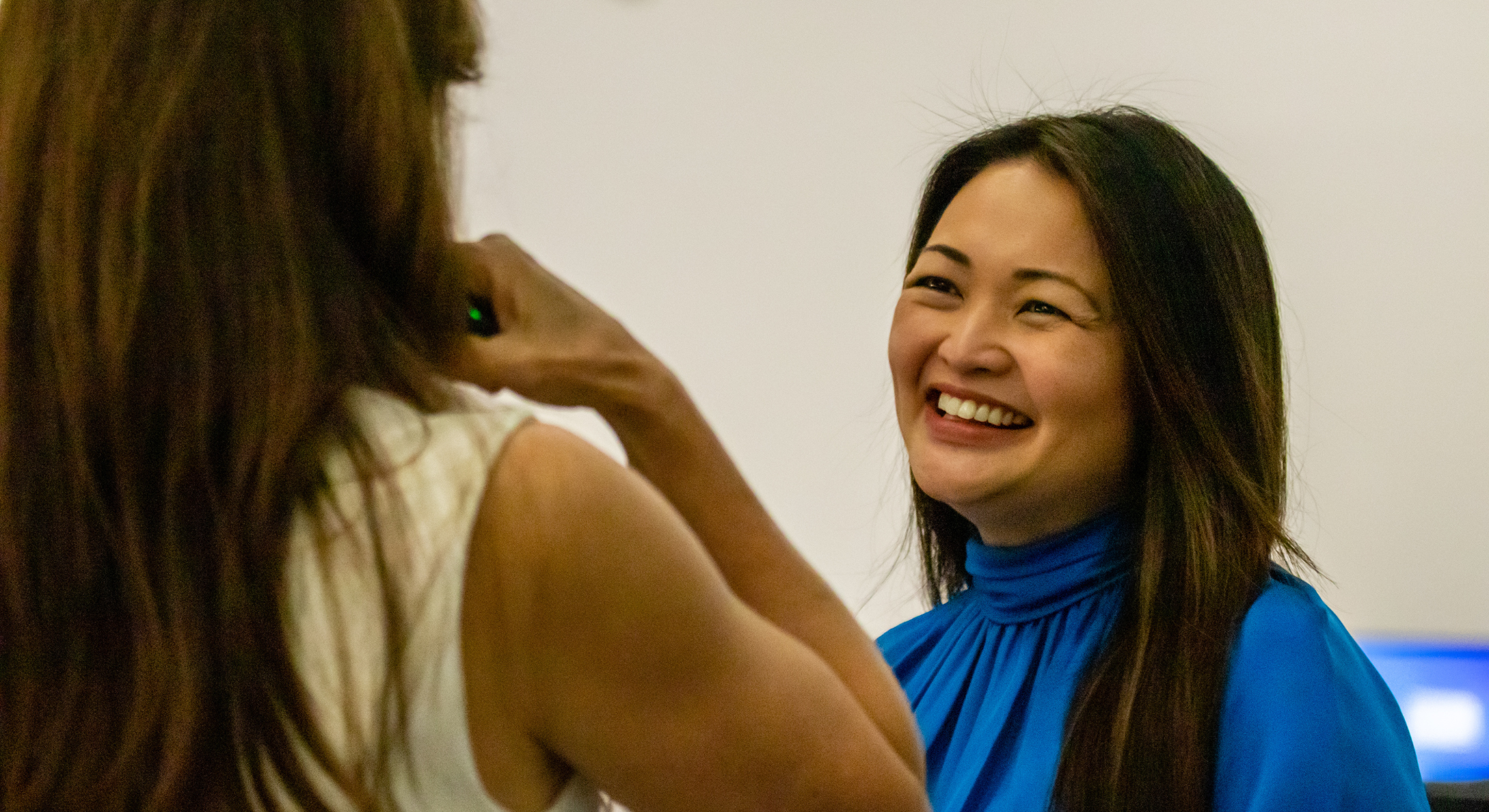 Picture of Katherine Lizardo in a blue blouse smiling at another female human being