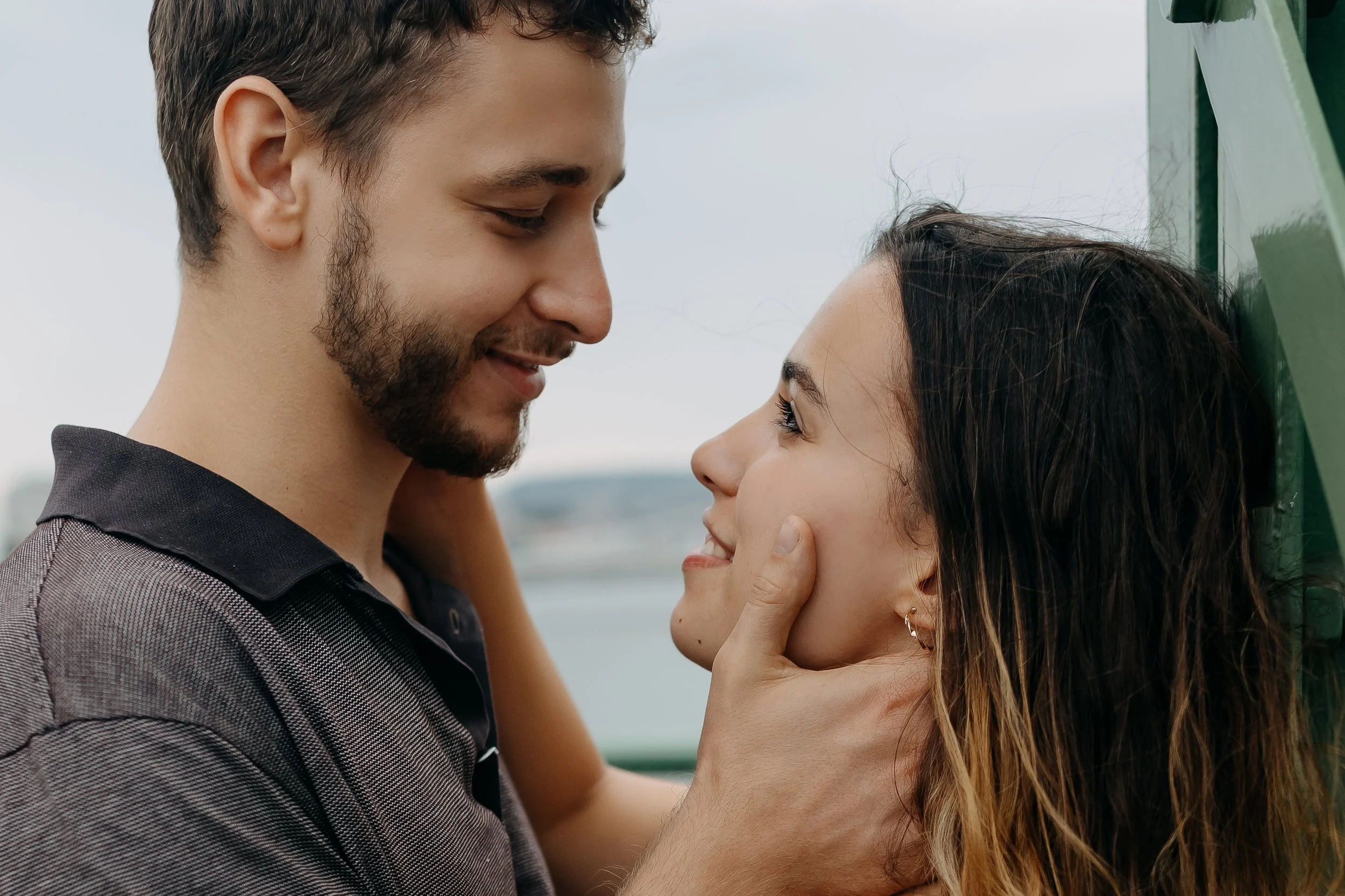 A man and woman sharing an intimate moment, with the man gently touching the woman's face and looking into her eyes.
