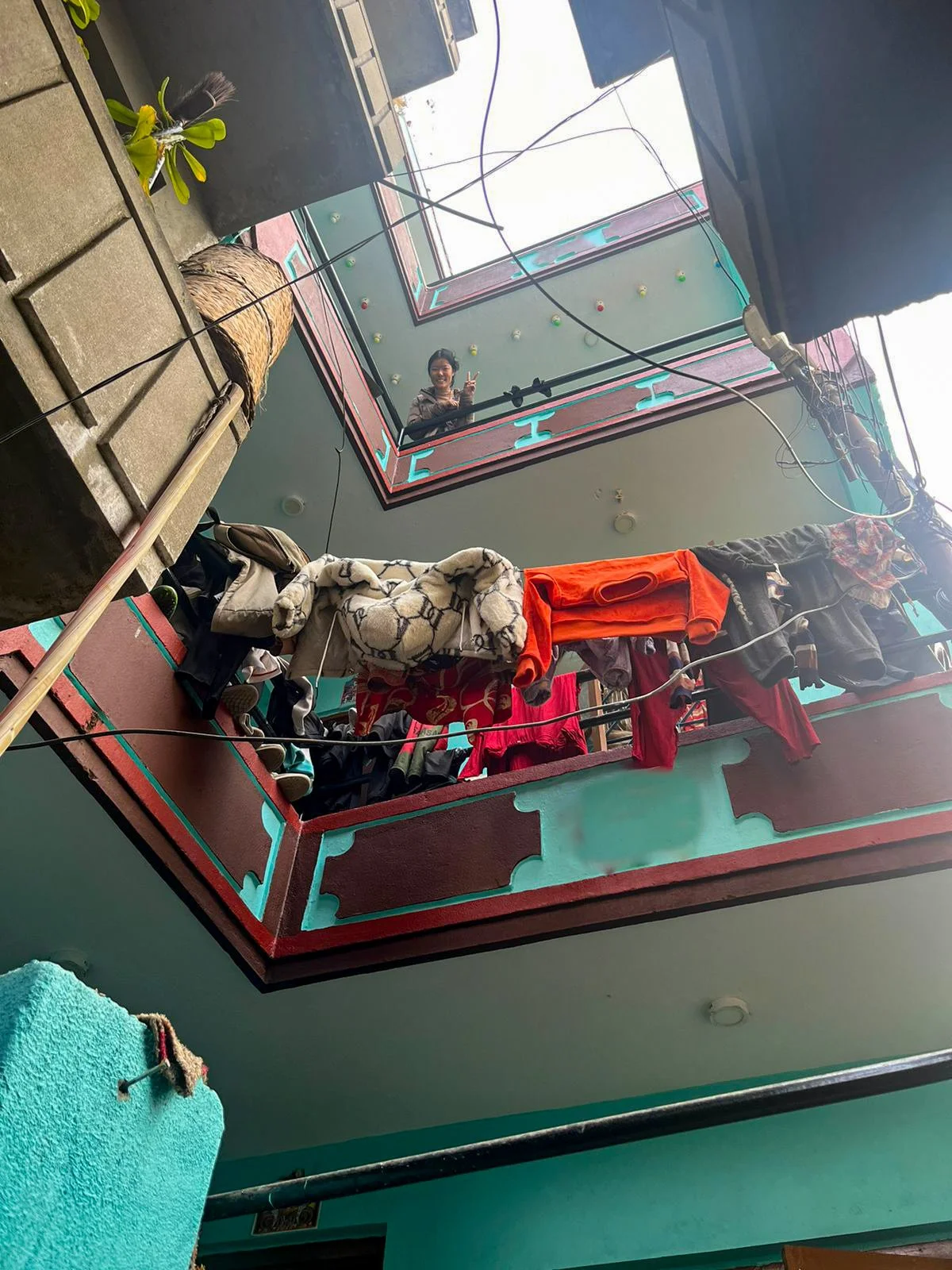  Tsering winkt aus dem 3. Stock. 