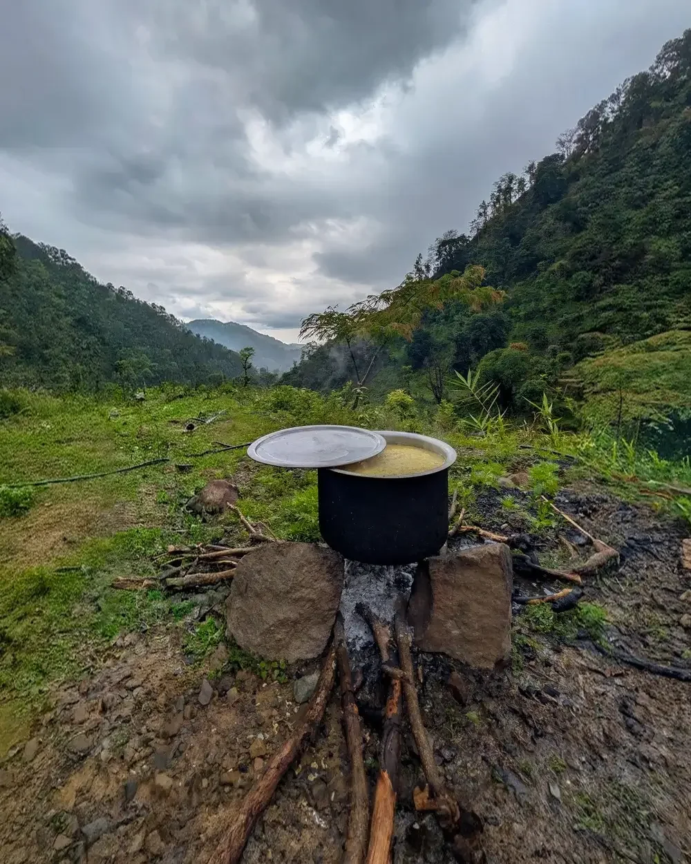 Schwarzer Metalltopf mit Reis kocht über offenem Feuer an der Schule in Chepang, Nepal