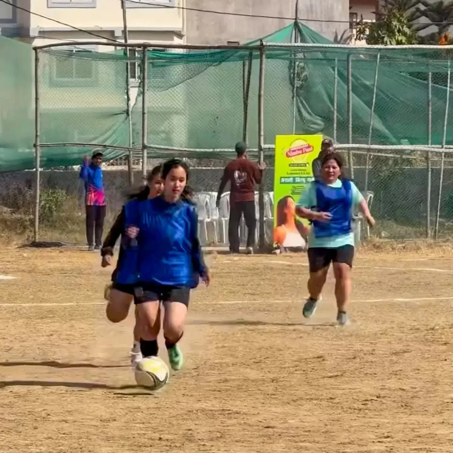 Ashita Tamang und junge Frauen beim Fußballspiel auf einem Sportplatz in Kathmandu, Nepal – Symbolbild für Frauenrechte und Sport.