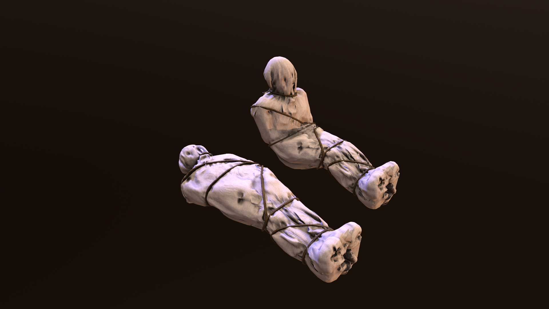 Two white bundles wrapped in cloth and tied with brown string, laid on a dark surface.