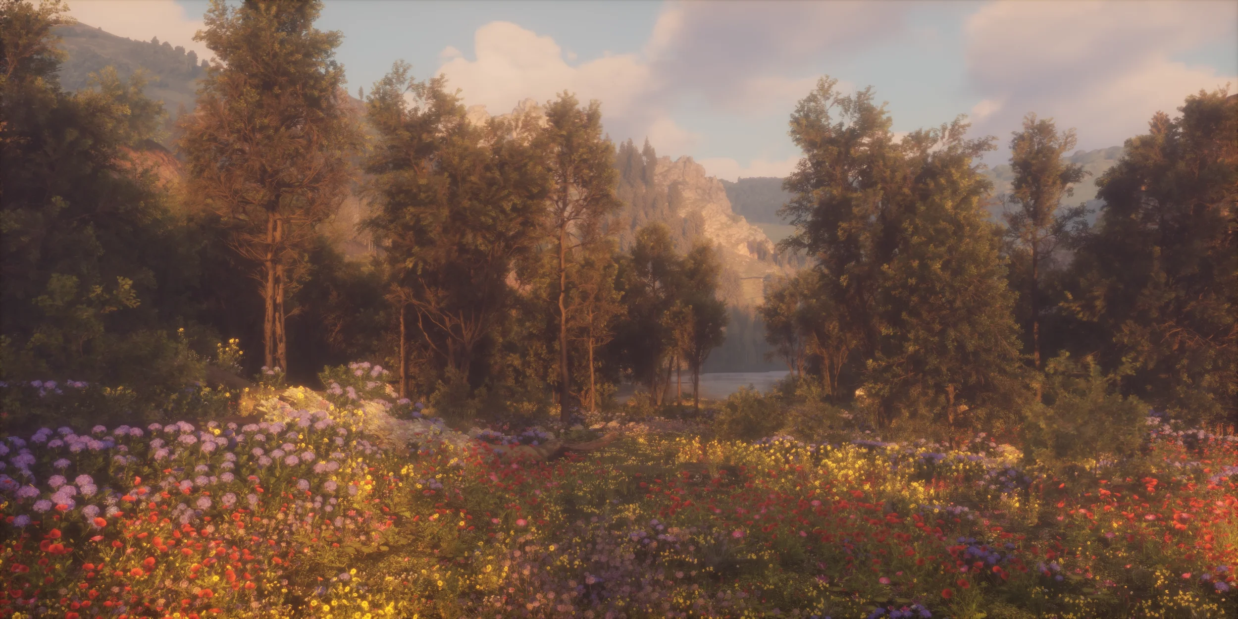 A peaceful landscape with a meadow of colorful flowers in the foreground, tall trees in the middle ground, and a mountain range with rocky cliffs in the background, under a partly cloudy sky.
