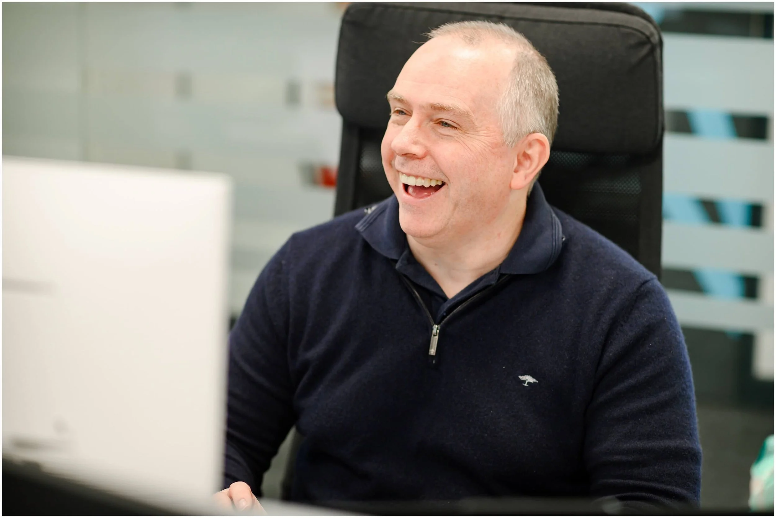 Smiling older man working at a computer in an office