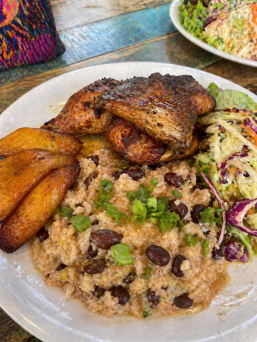 A plate of Caribbean rice and beans cooked in coconut milk served with grilled chicken, fried plantains, and coleslaw in Costa Rica.