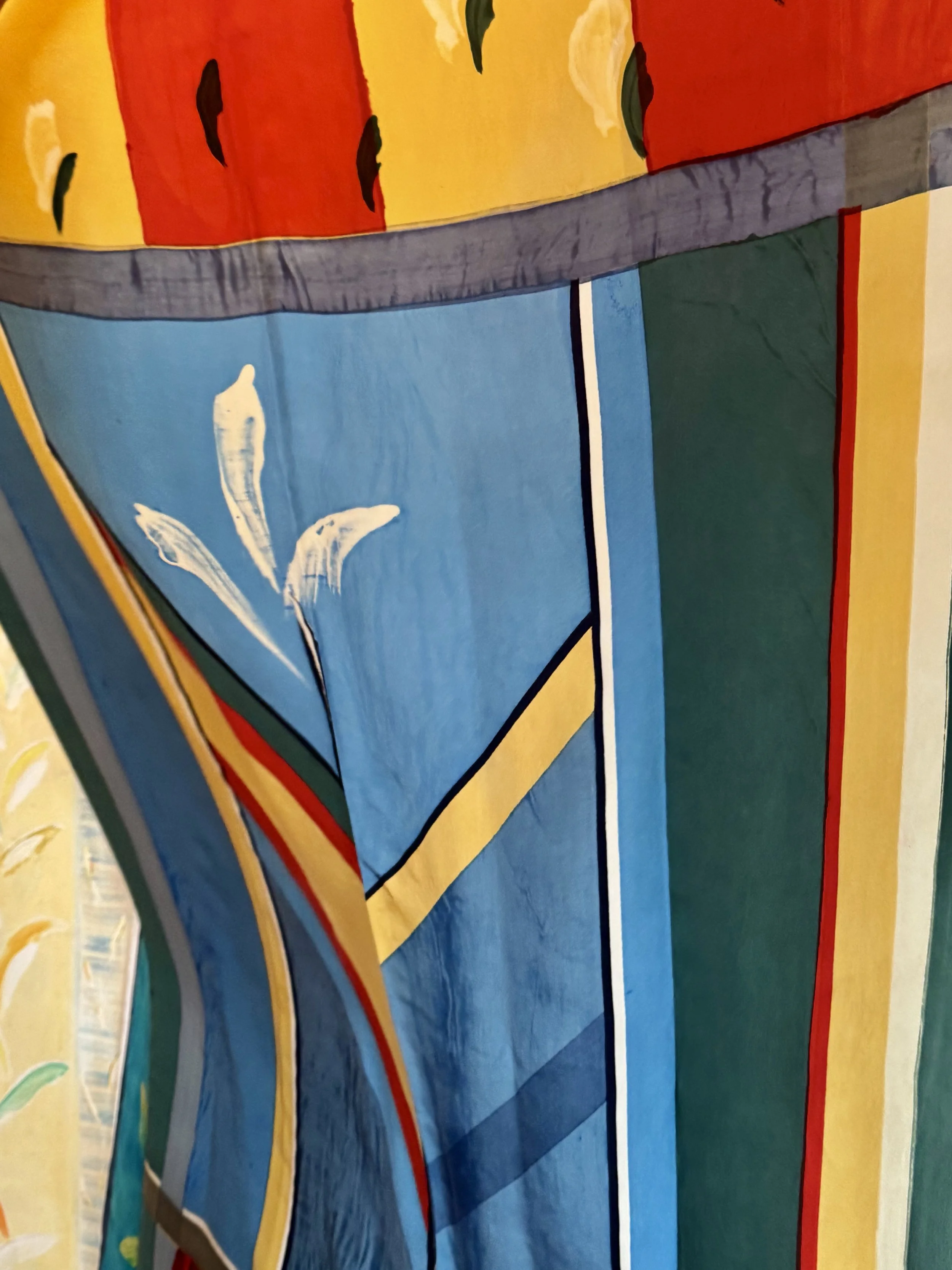 Colorful abstract textile art with bold stripes and painted floral details