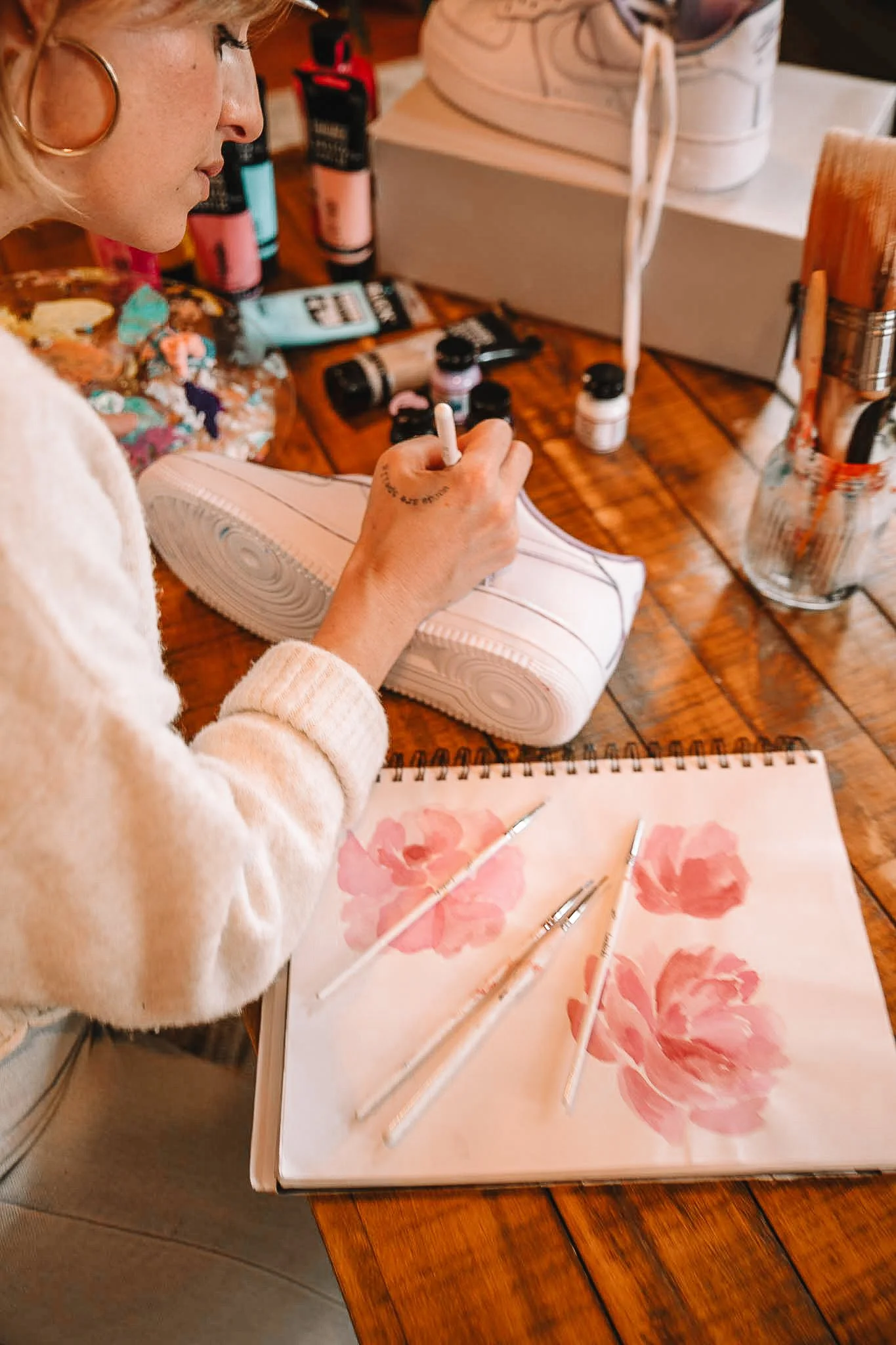 Artist painting sneakers flowers