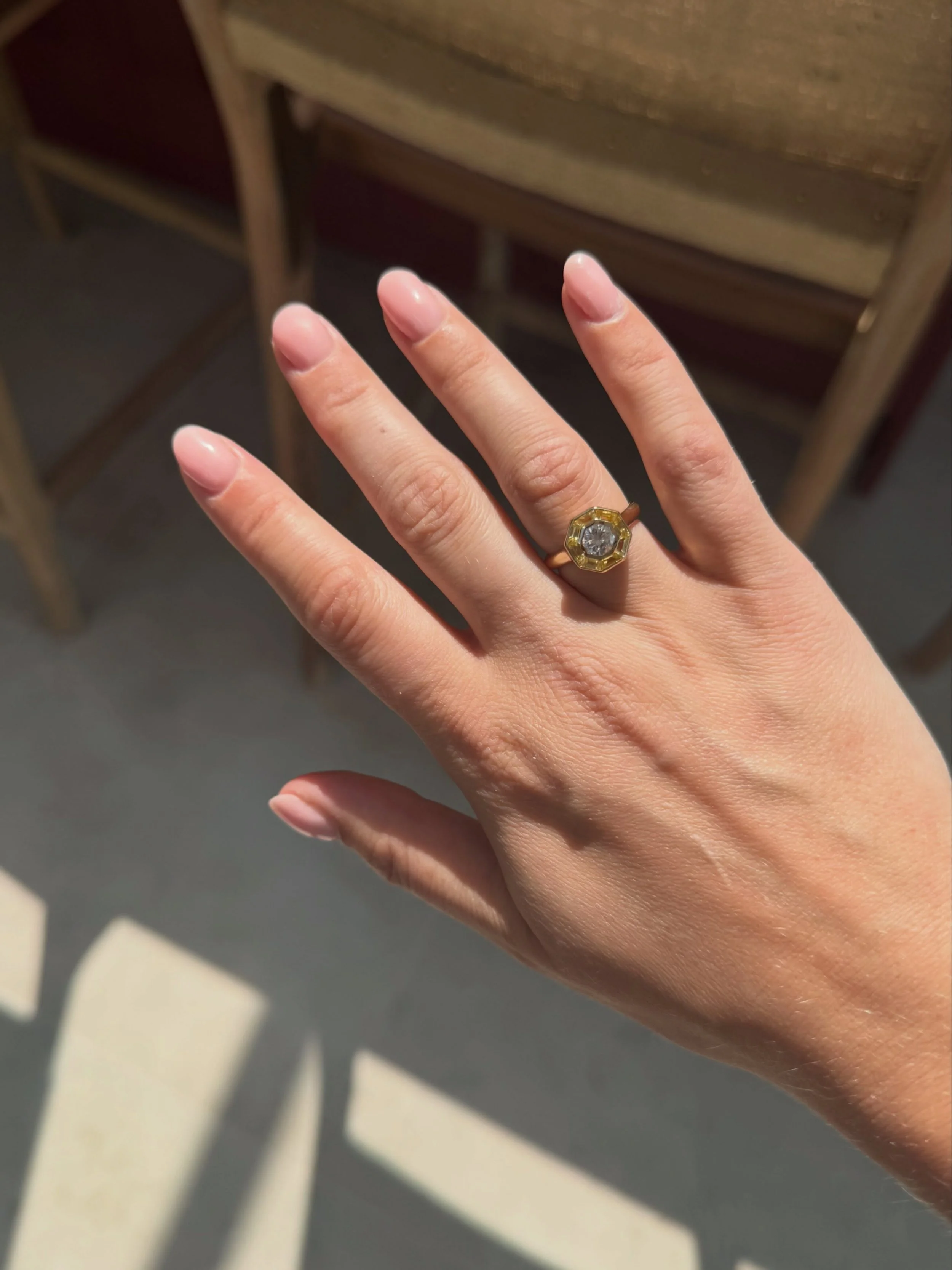 For this bespoke ring, we started with the client&rsquo;s own diamond.

I sourced yellow sapphires to complement it, looking at the colour, cut and proportions of each stone, before designing the ring around the central diamond. I love working this w