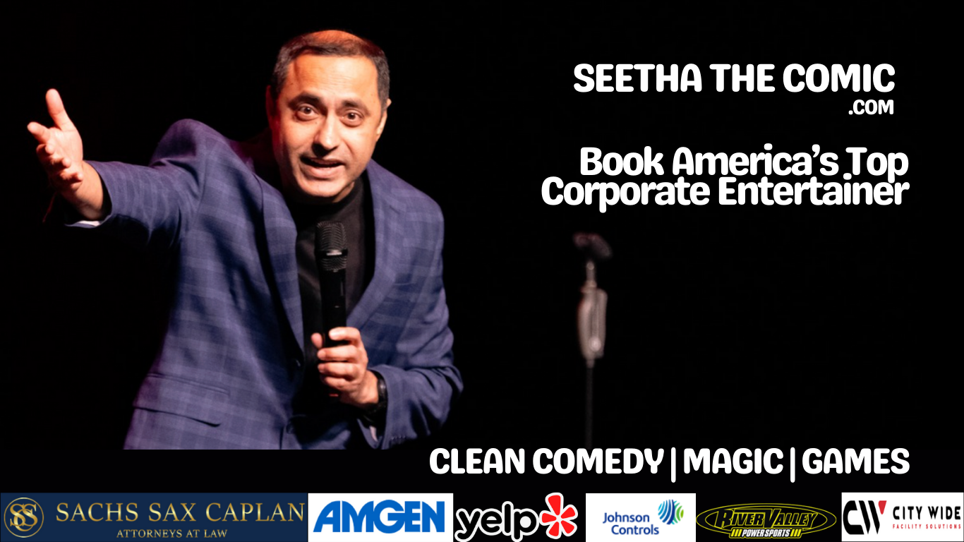 Stand-up comedian Seetha the Comic performing on stage with a microphone, wearing a dark blazer and gesturing with his right hand, against a black background with promotional text and logos.