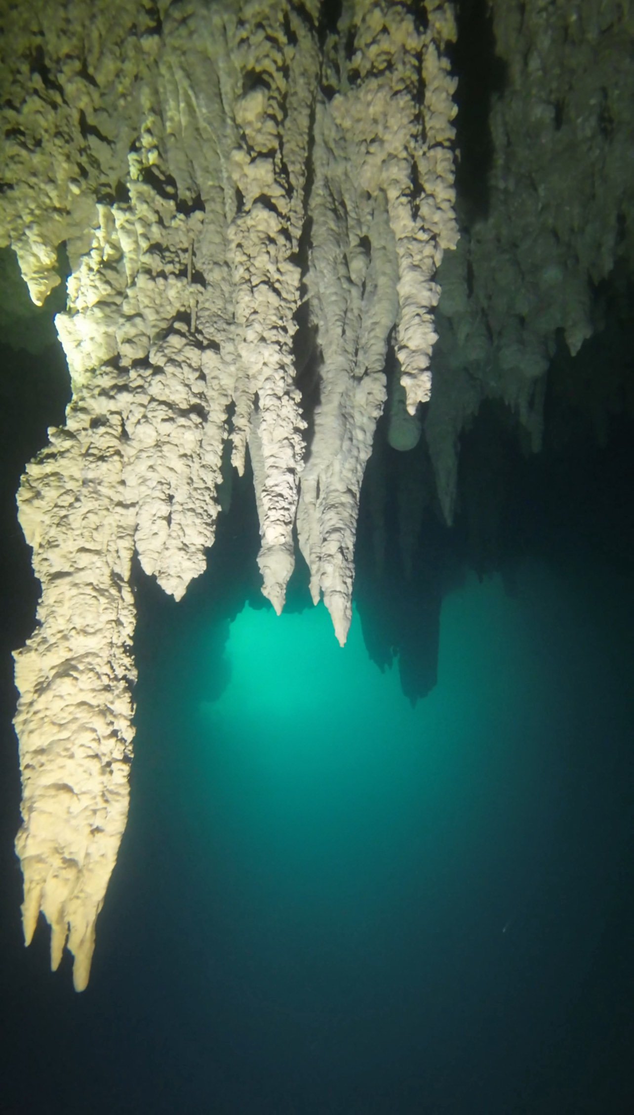 Underwater cave with stalactites and a turquoise blue underwater pool