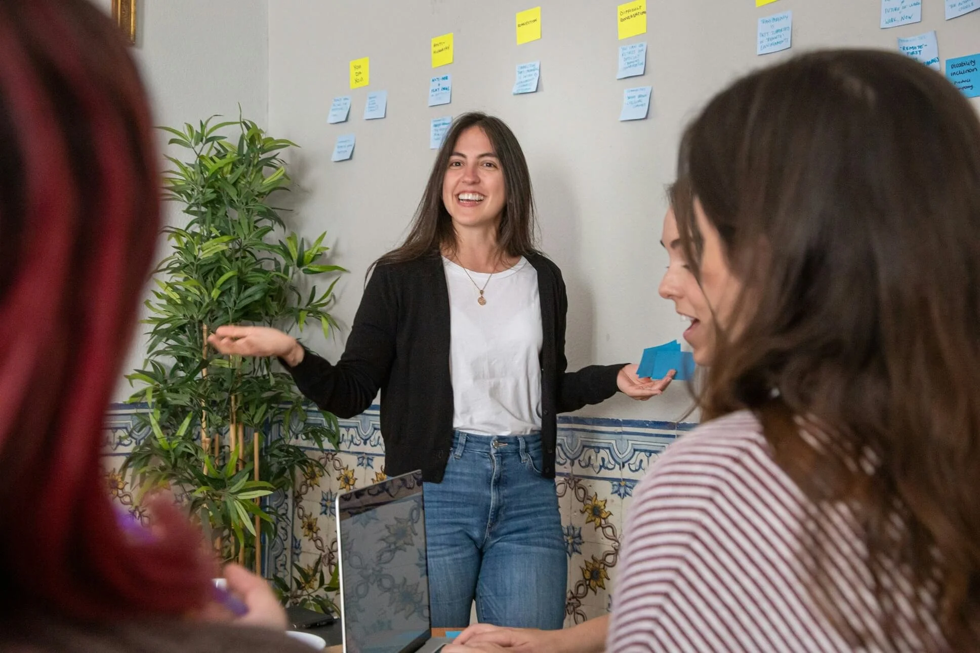 woman presenting in front of a wall of post-it notes