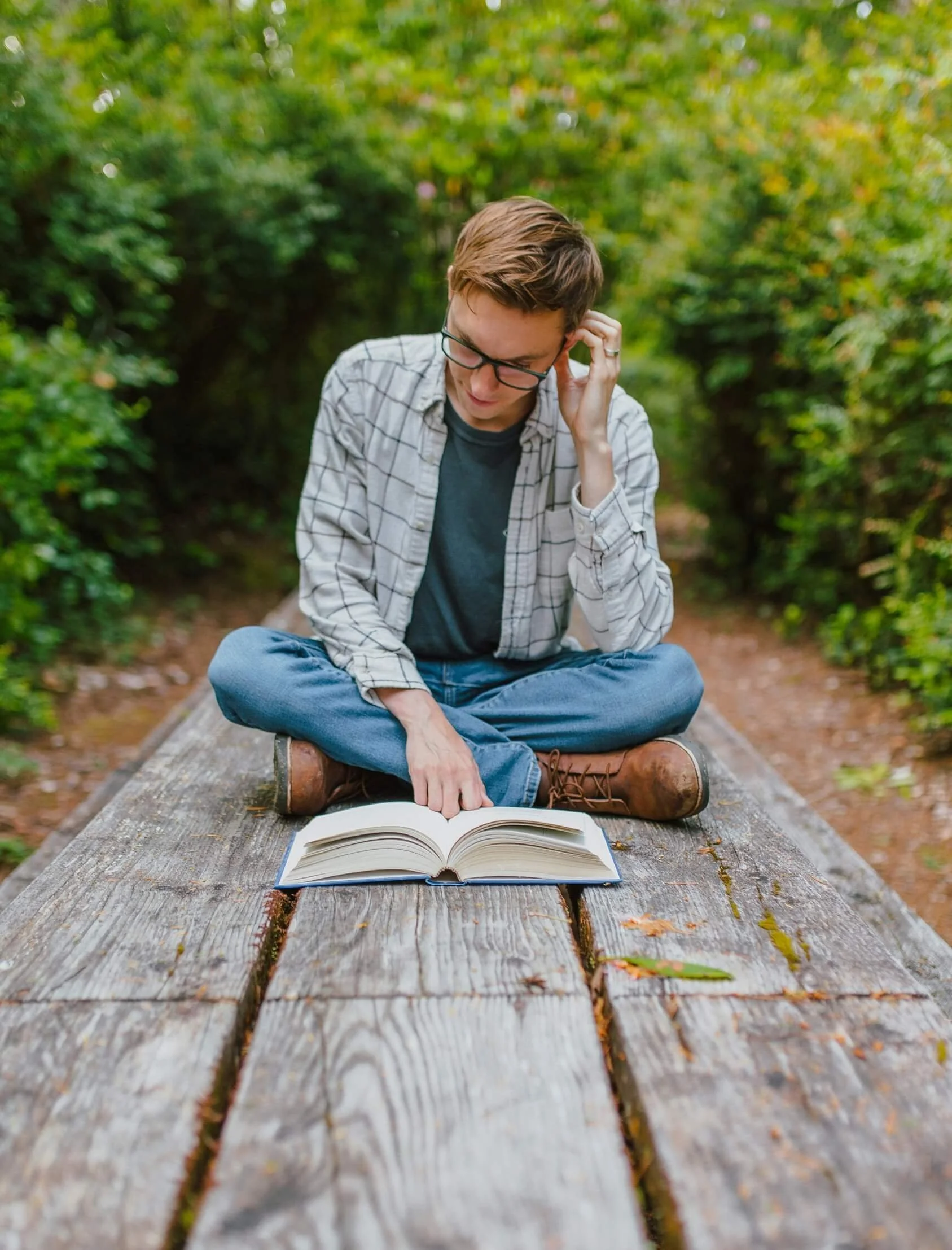 man reading a book on a wooden table