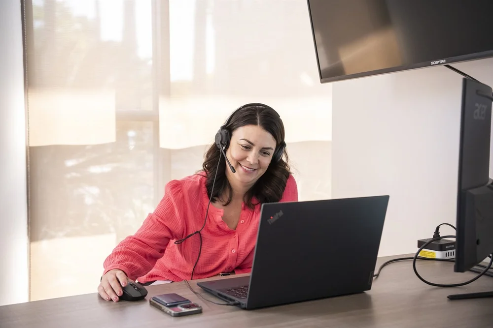 An Excelerate consultant on a headset call at a laptop.