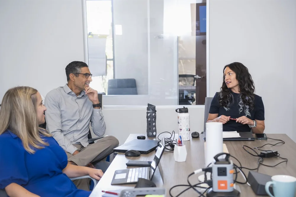 Excelerate consultants in discussion around a conference table.