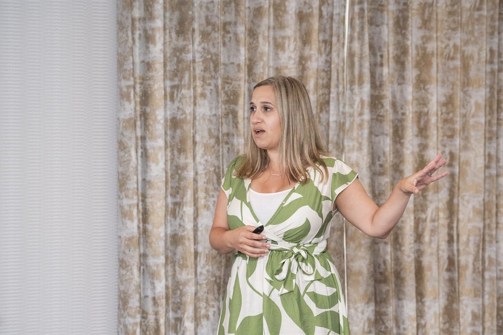An Excelerate facilitator leading a session in front of a presentation screen.
