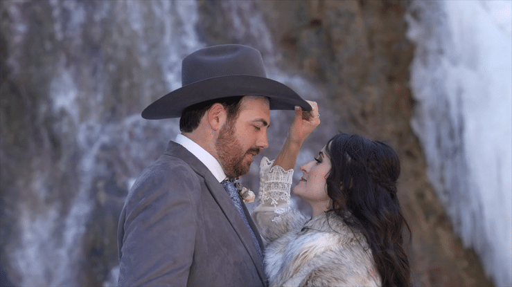 Laurie’s customers, Mariana and Carmen holding hands on a green lawn on their wedding day.