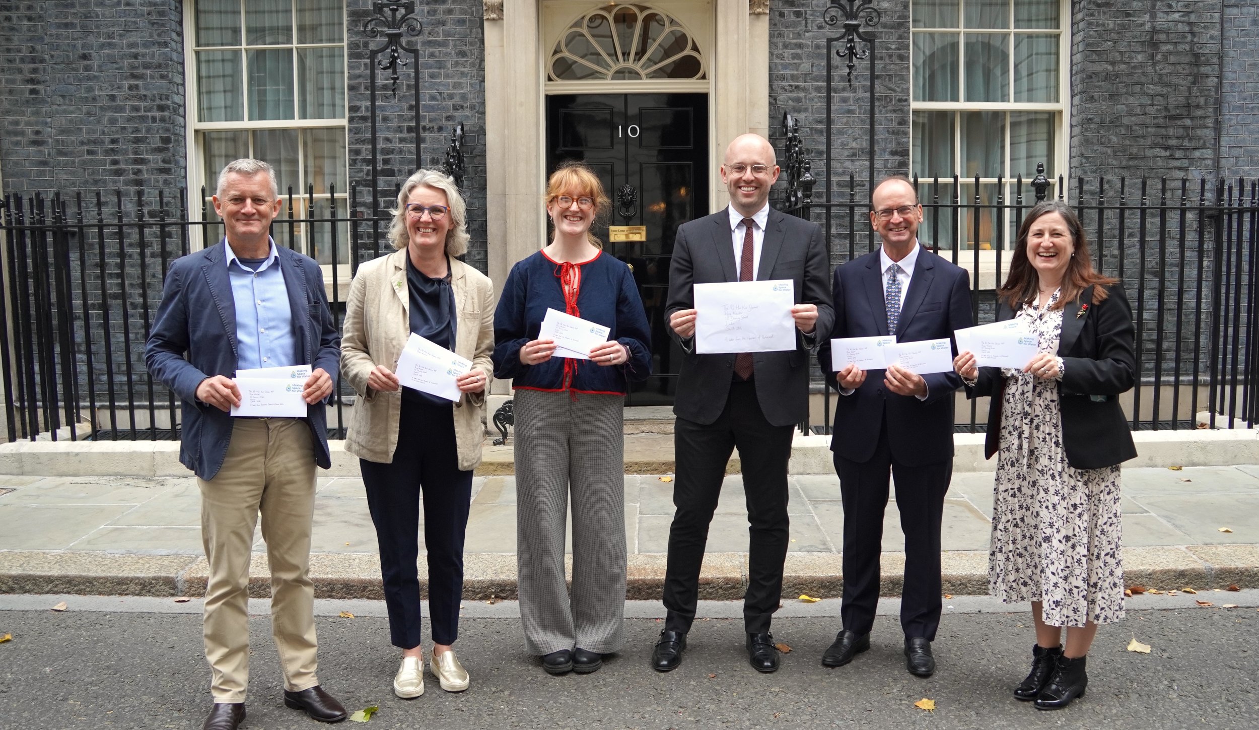 Roisin stands outside No.10 Downing Street with a mixture of MPs and Chief Executives to petition government to take water quality seriously.
