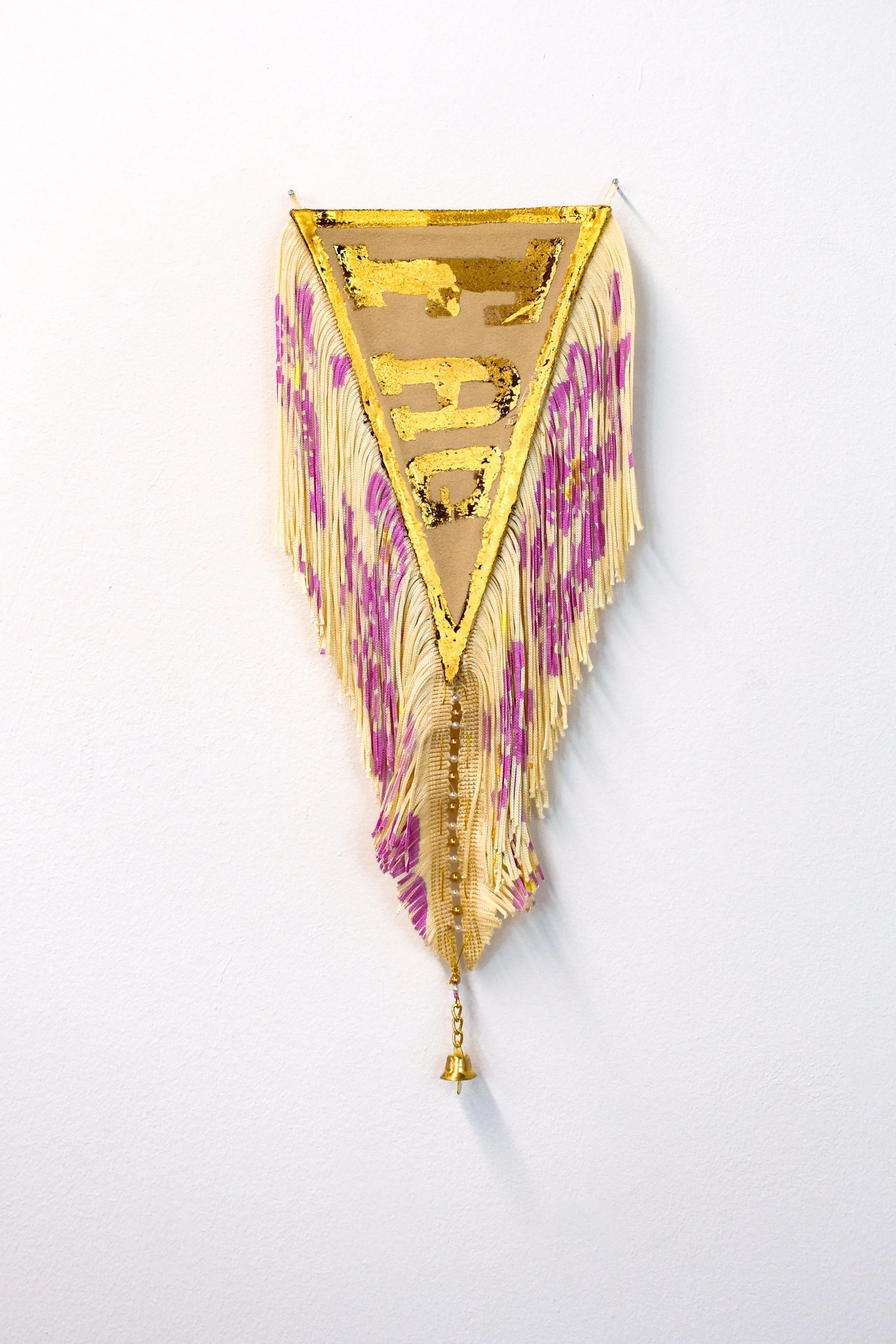 raise your fag (2025). textile foil on suede, disperse dye on polyester fringe, gold thread, beads, bell. 7" x 12".