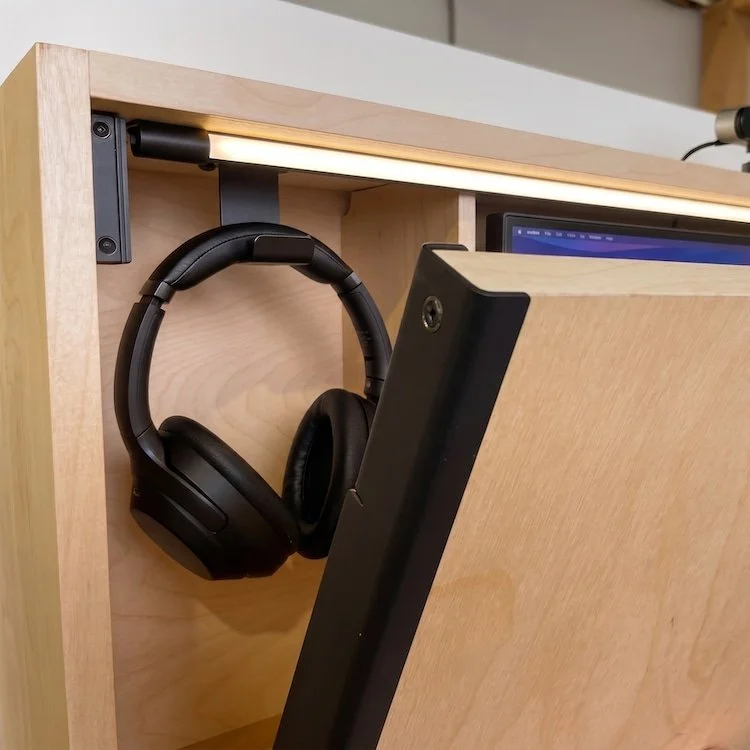 detail image showing murphy desk partially opened, revealing headphones a light and a monitor accessory
