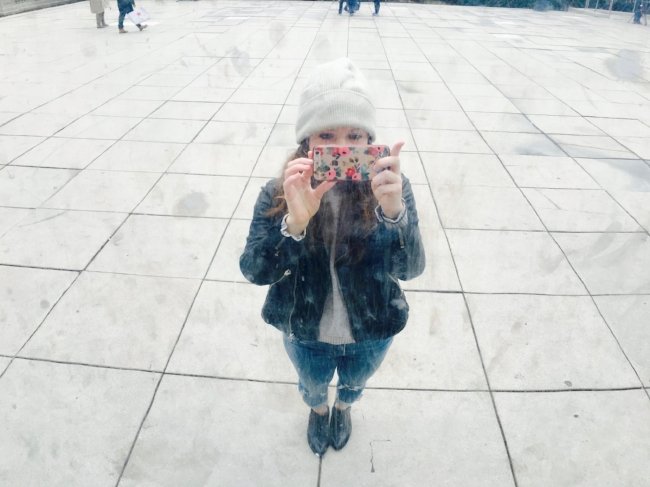 Sarah Dubow, health and wellness coach, taking a photo in the reflection of the Chicago Bean