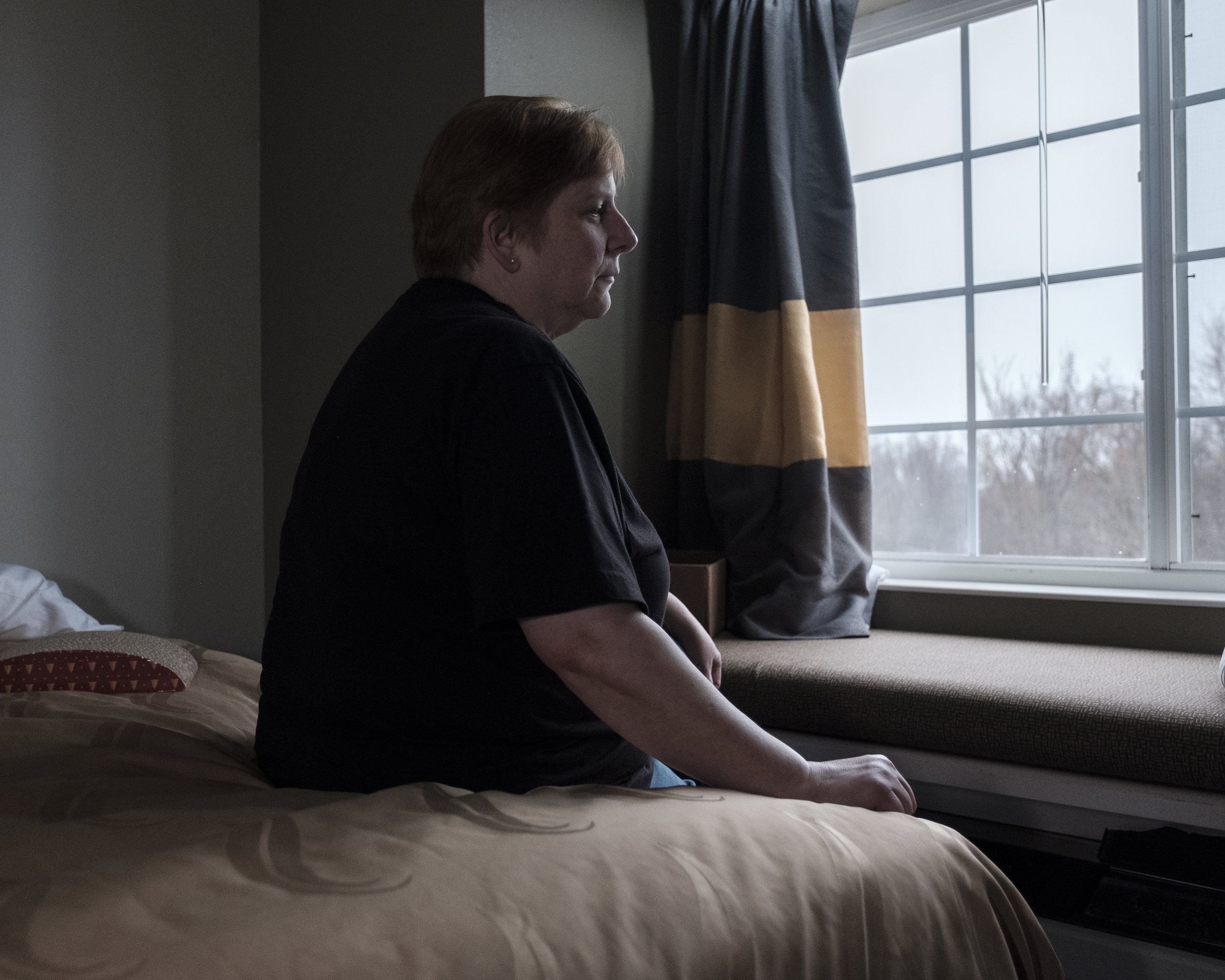 Renee Funkhouser sits on her bed in a hotel room in North Lima. She counts her blessings, but she’s frustrated by the way that all of the little disruptions, like the 15 minutes added to her commute to work, all add up. To her, the Norfolk Southern t