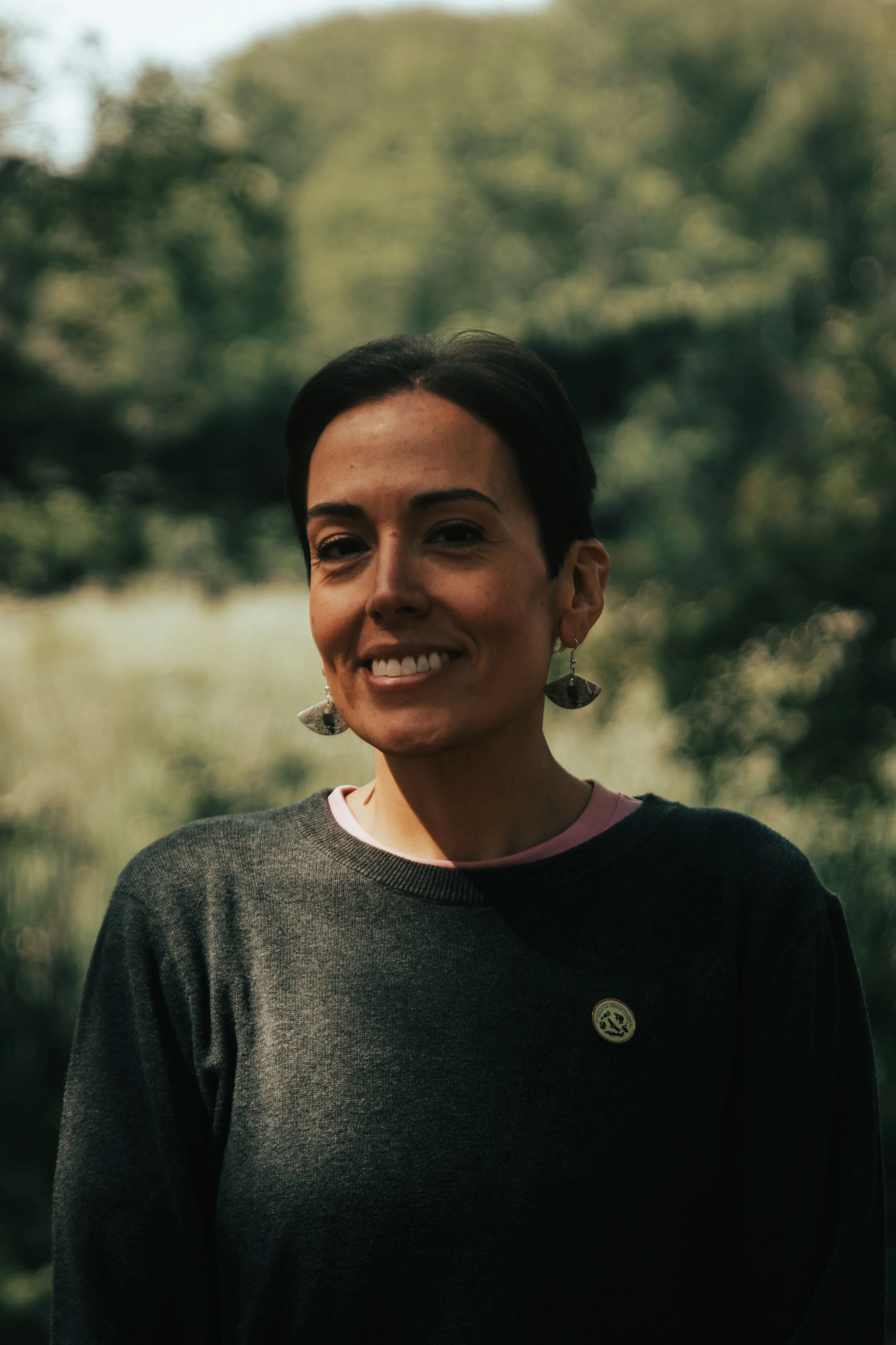 Portrait of Red Cliff Band Chairwoman Nicole Boyd smiling outdoors, captured in natural light during a community moment.