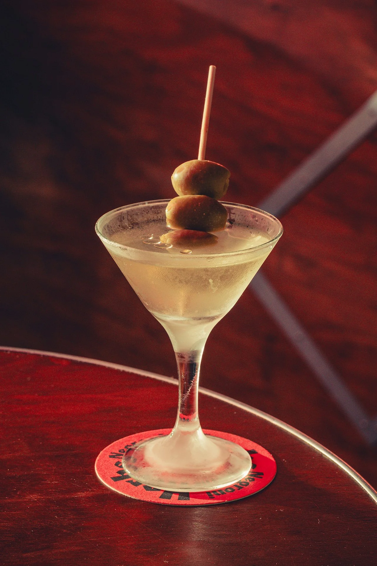 A Dirty Martini at Herbs Taverne, in an ice-cold martini glass, garnished with 3 olives on a skewer.
