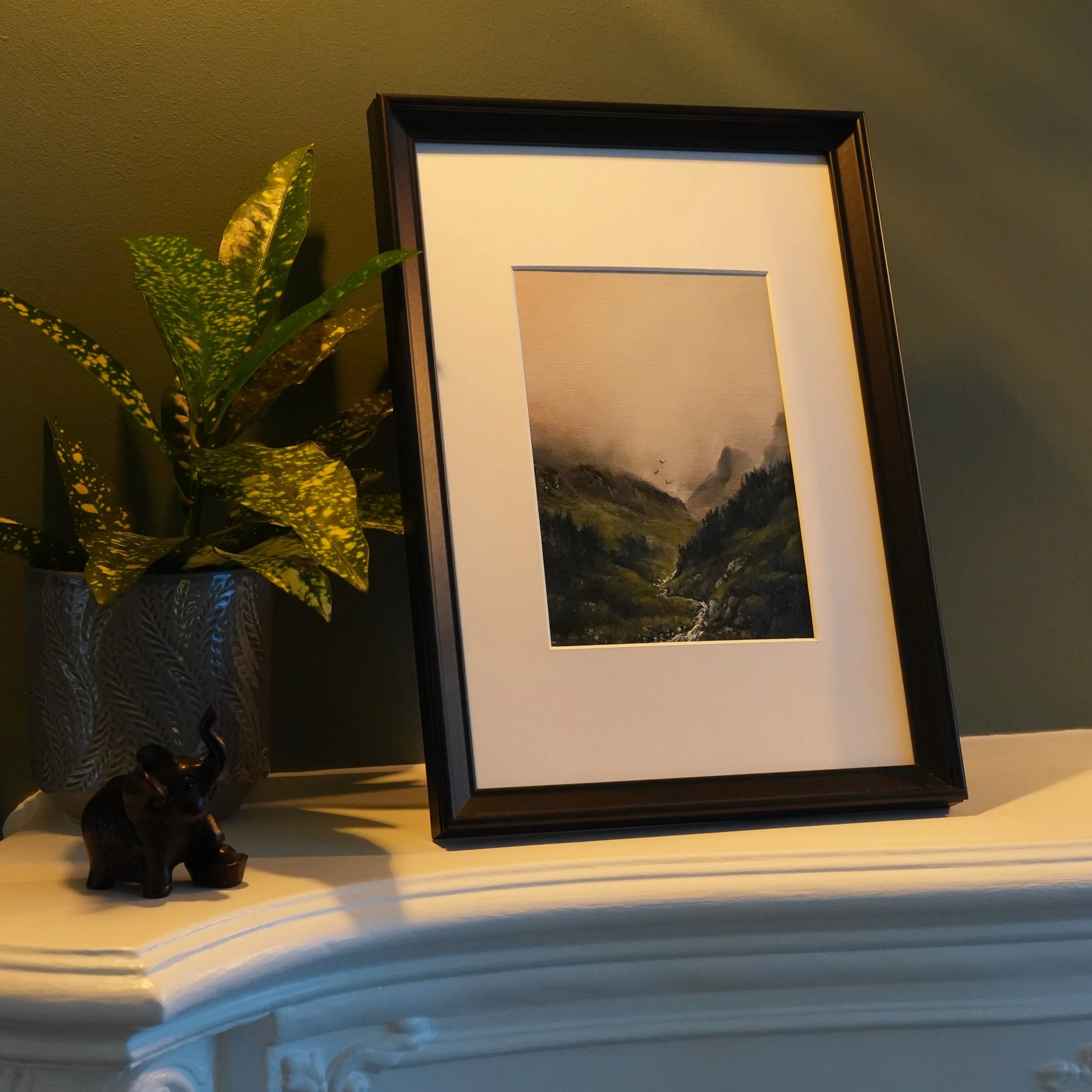 This is what a small painting does in a room. Not much, loudly &mdash; just changes what the corner is about.

Mist coming down a valley, birds crossing the gap, a stream picking its way through. Five inches of somewhere much colder than this flat.

