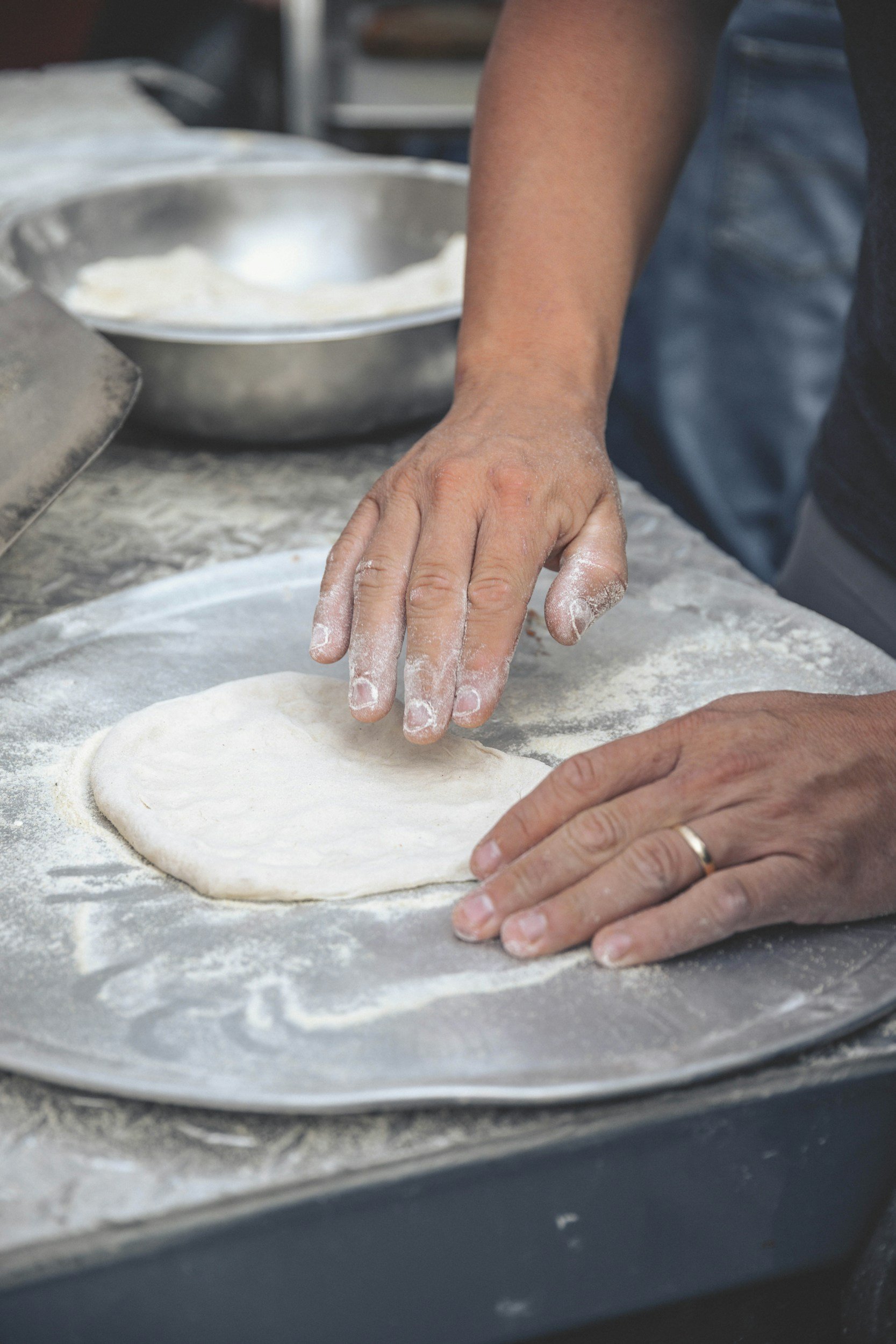 a person handling sourdough pizza dough properly at home