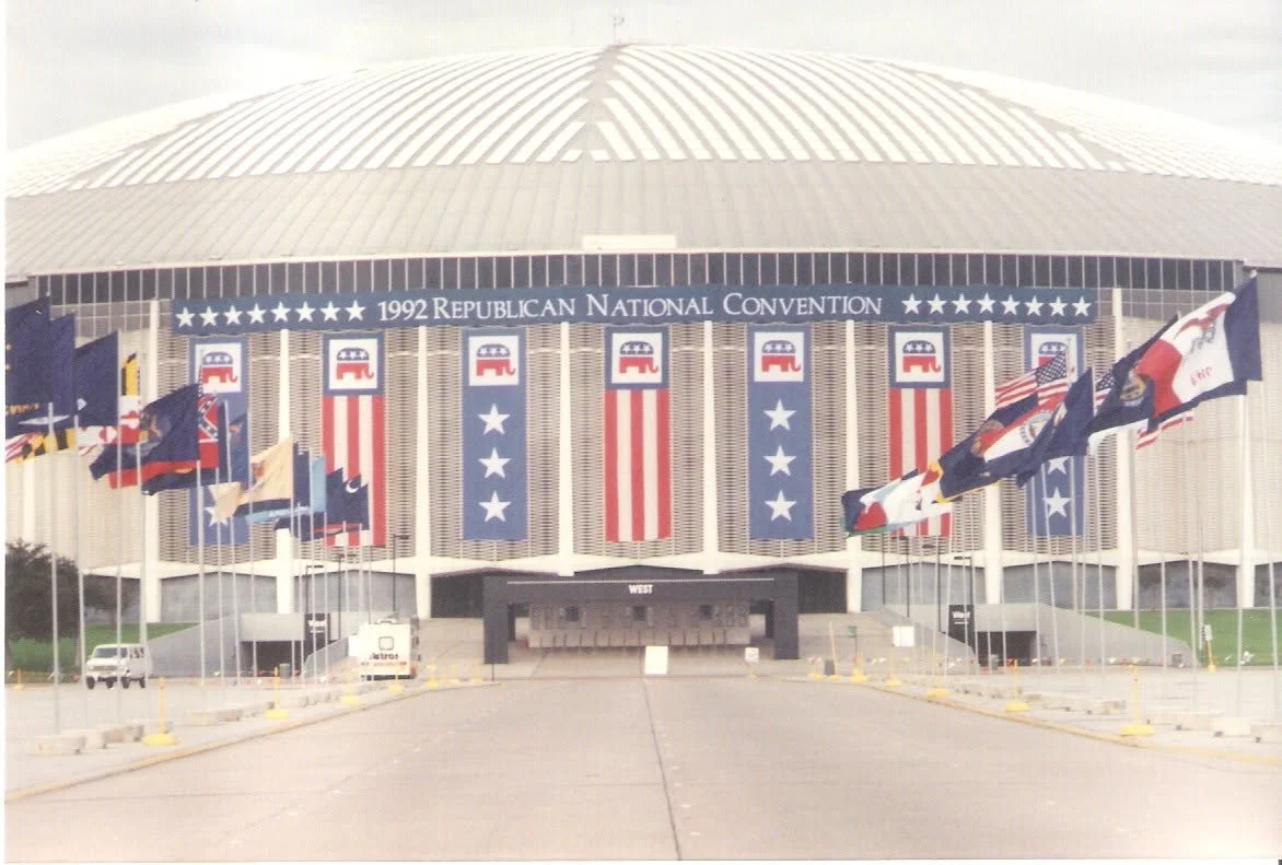Exterior of a large convention center decorated with flags and banners for the 1992 Republican National Convention, featuring American flags, Republican Party symbols, and patriotic decorations.
