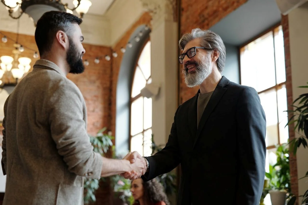 A contractor shaking hands with his new customer that he gained after investing in website accessibility services  to make his website more accessible, which expanded his reach and company's reputation.