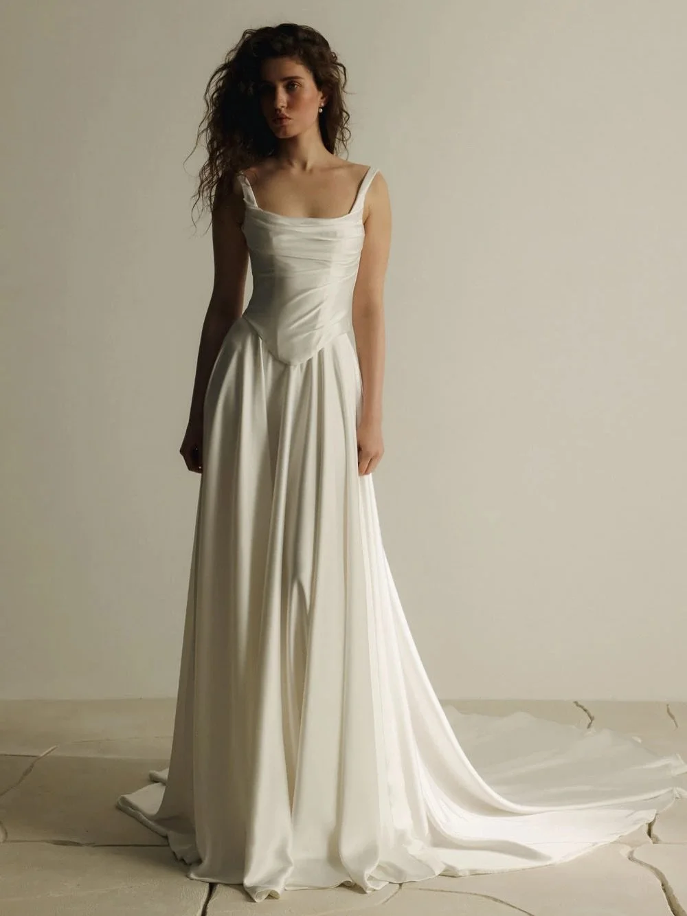There&rsquo;s a quiet confidence to certain gowns, Artie by @evalendel embodies it. A refined corset with soft draping, paired with a fluid satin skirt and chapel-length train, creates a look that feels both sculpted and effortless. Modern simplicity