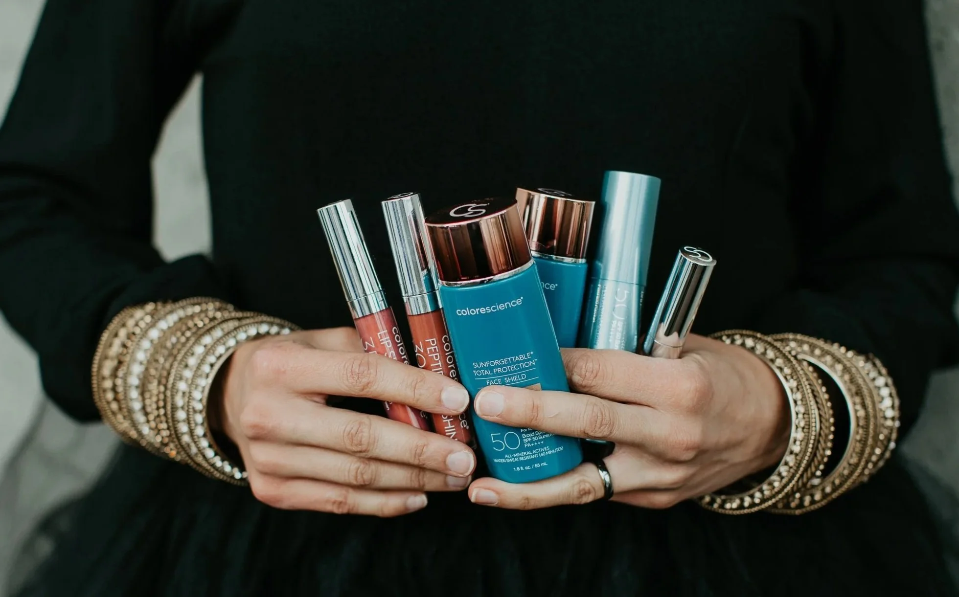 Simi Kennedy holding Colorescience SPF and ZO Skin Health skincare products available at Sona Medical Aesthetics Newcastle WA