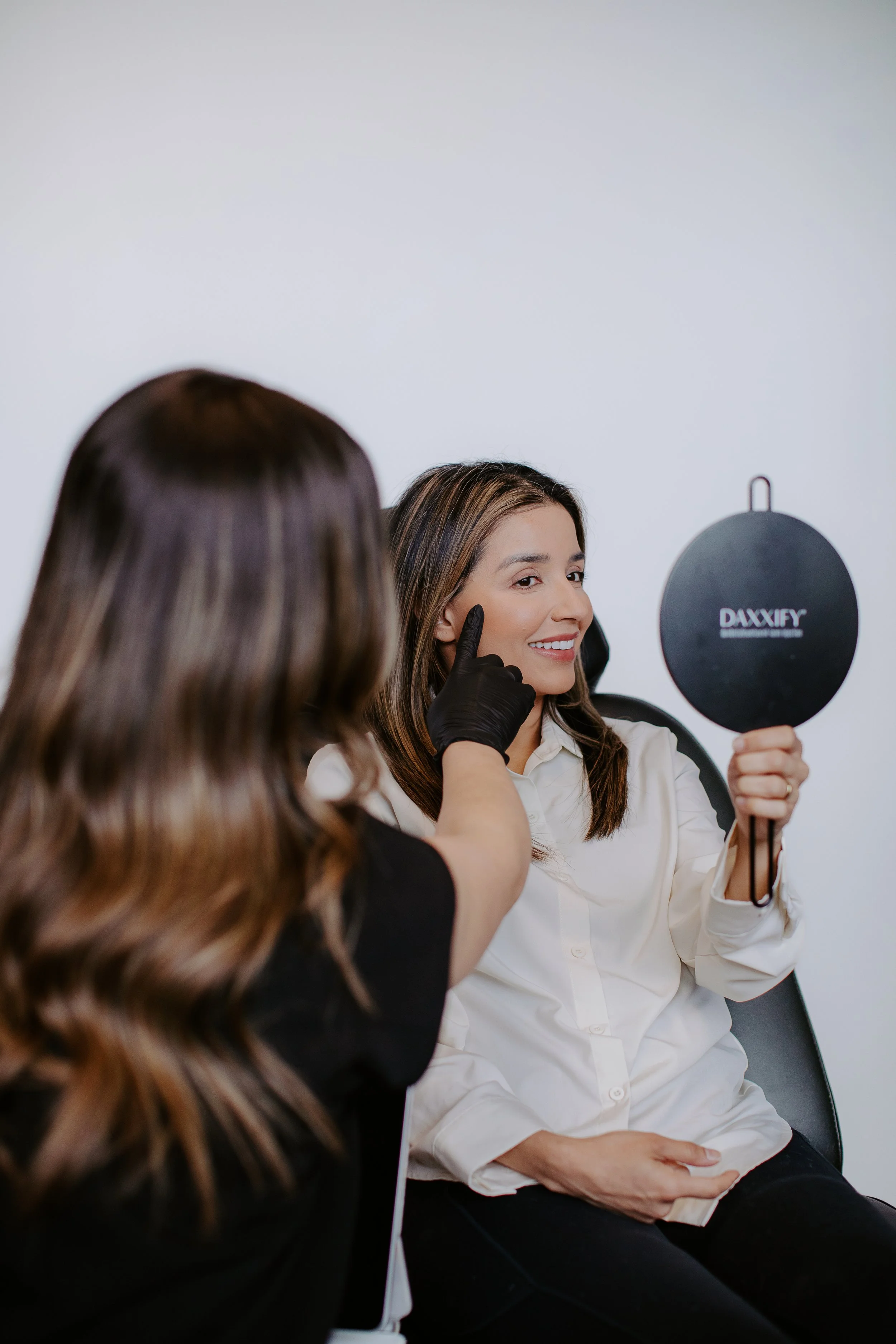 Provider pointing to a patient's cheek during a laser consultation for facial rejuvenation at Sona Medical Aesthetics Newcastle WA