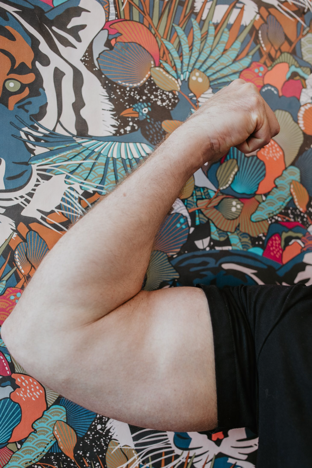 Lance Kennedy ARNP flexing bicep against Sona signature wallpaper representing BodyTone muscle strengthening treatments at Sona Medical Aesthetics Newcastle WA